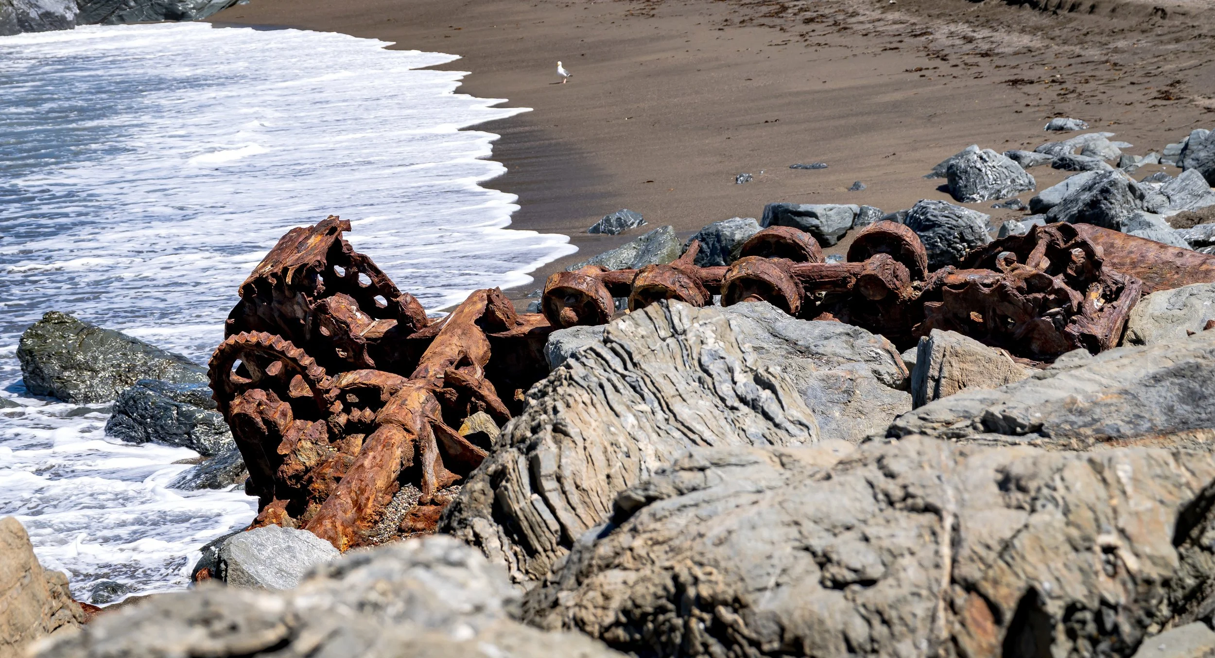 Machinery embedded in rock wide against sandy beach.jpg