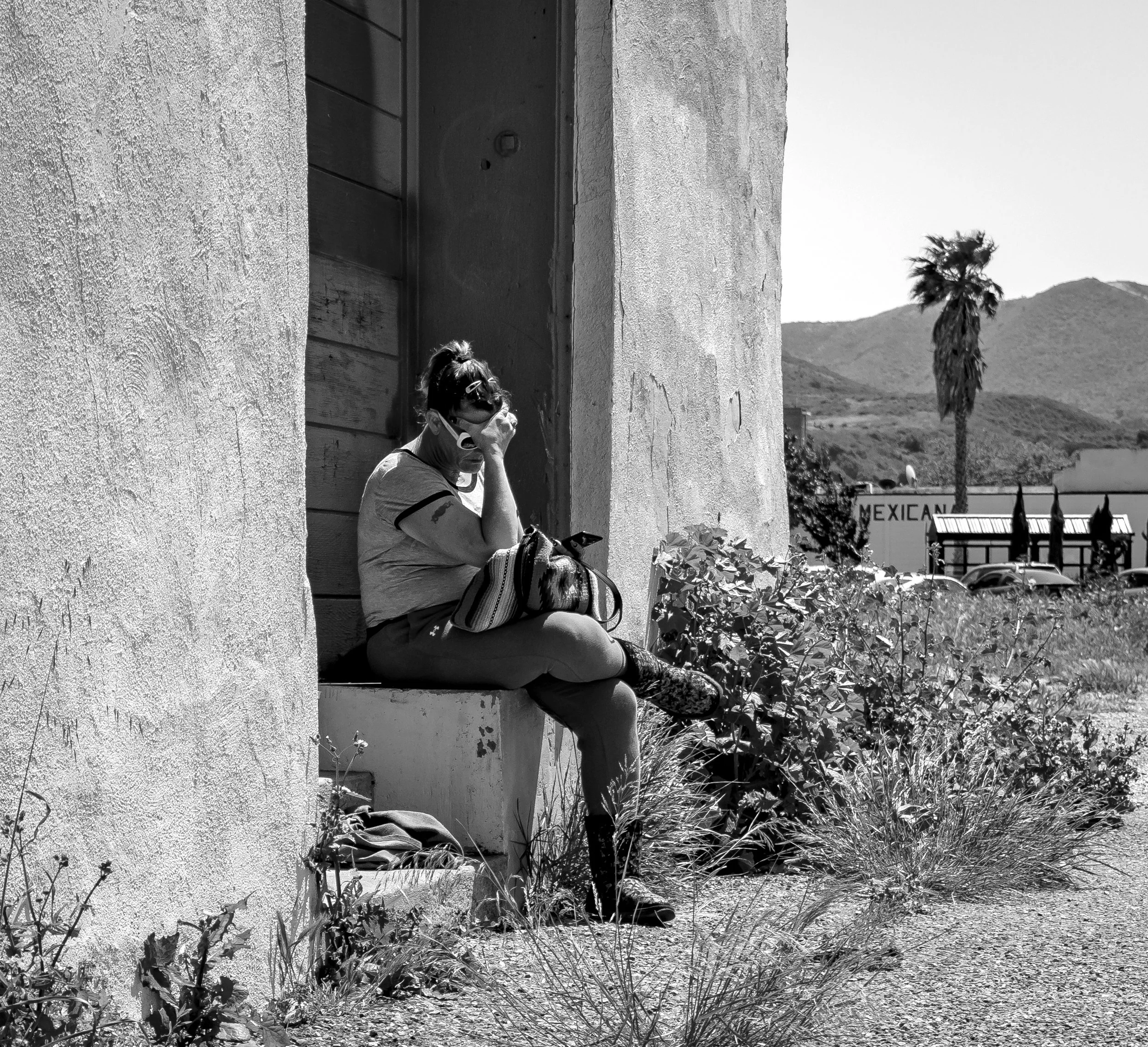 Woman sitting on building side bnw.jpg