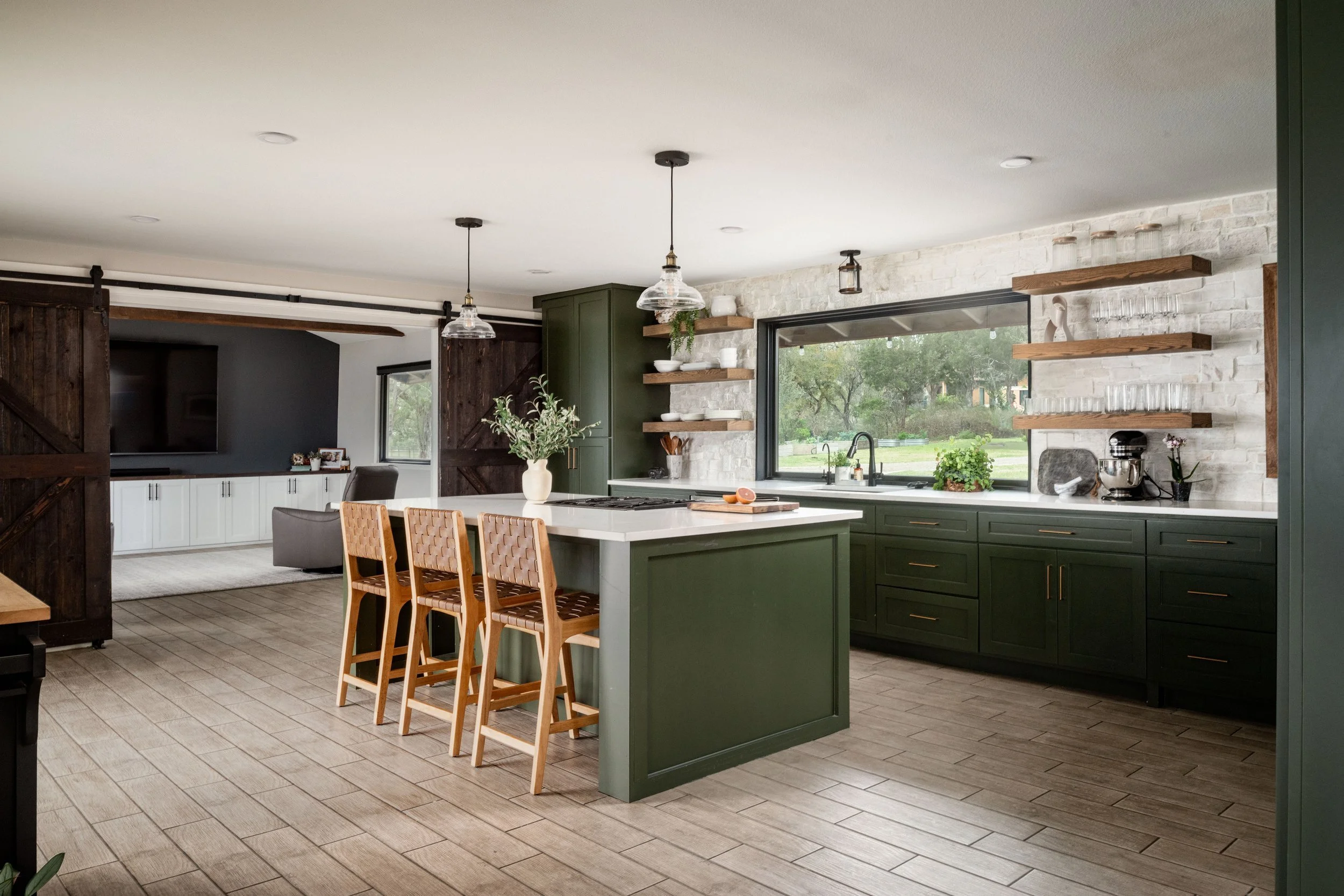 Modern Texas kitchen with large island, green cabinets, and natural light