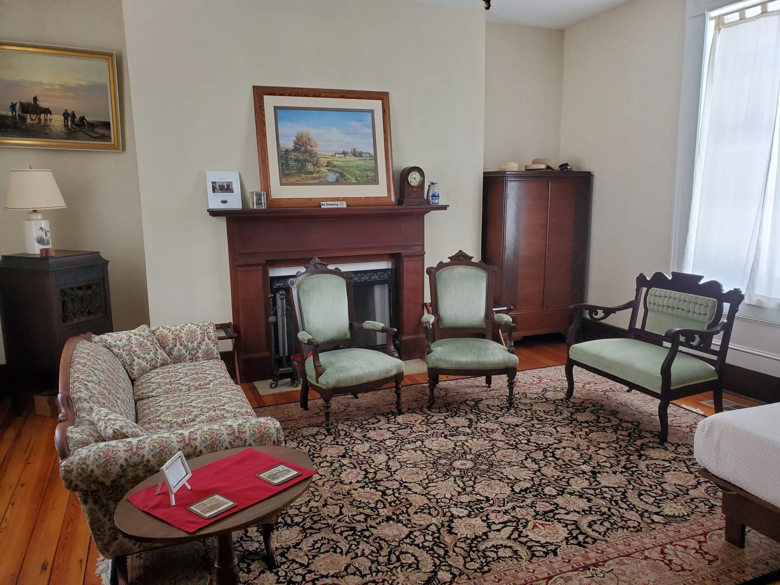 Spacious room with queen bed, antiques, comfy chairs and couches, fireplace and window