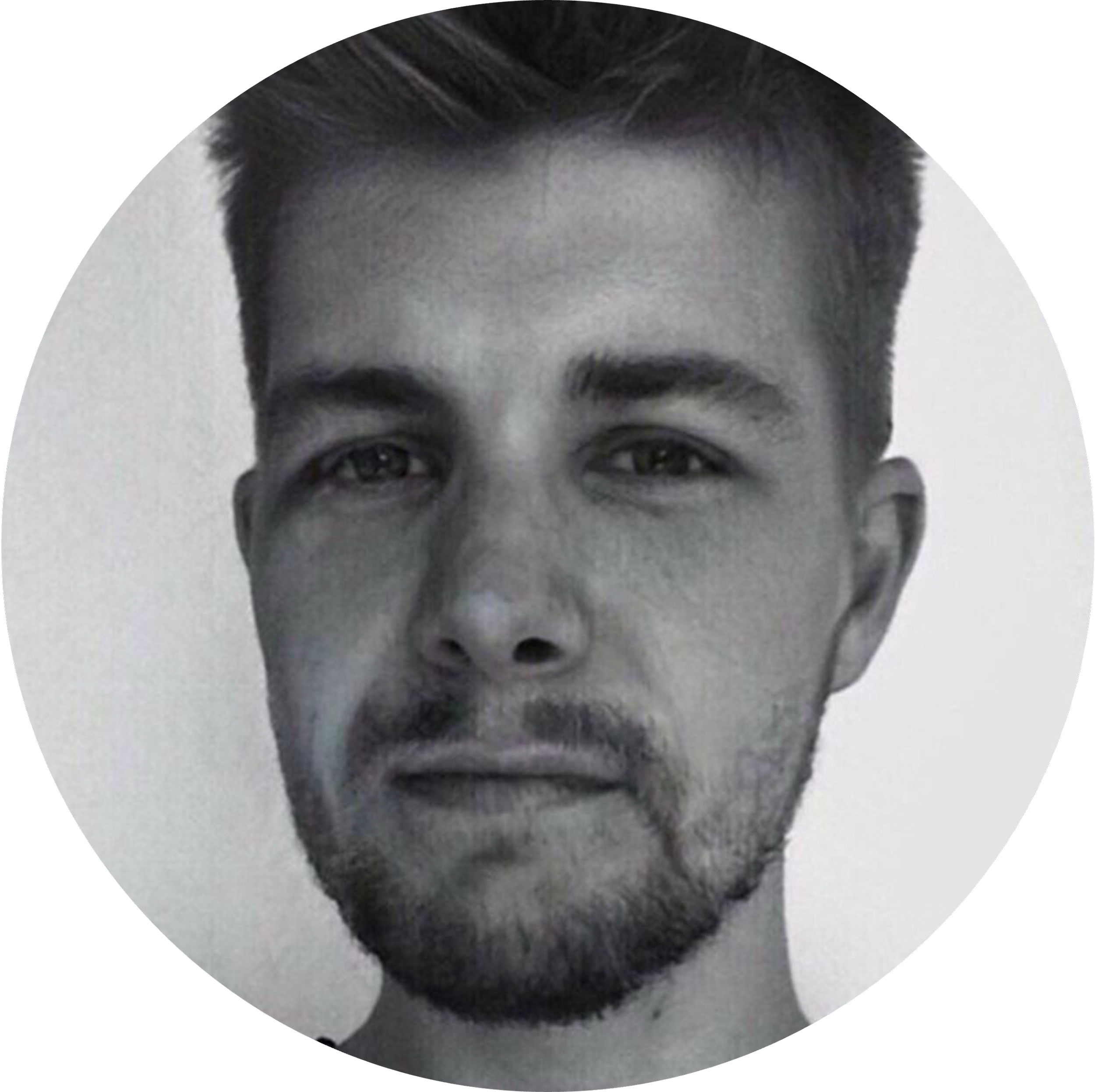 Sort-hvid portrætfoto af en ung mand med kort, mørkt hår og skæg.