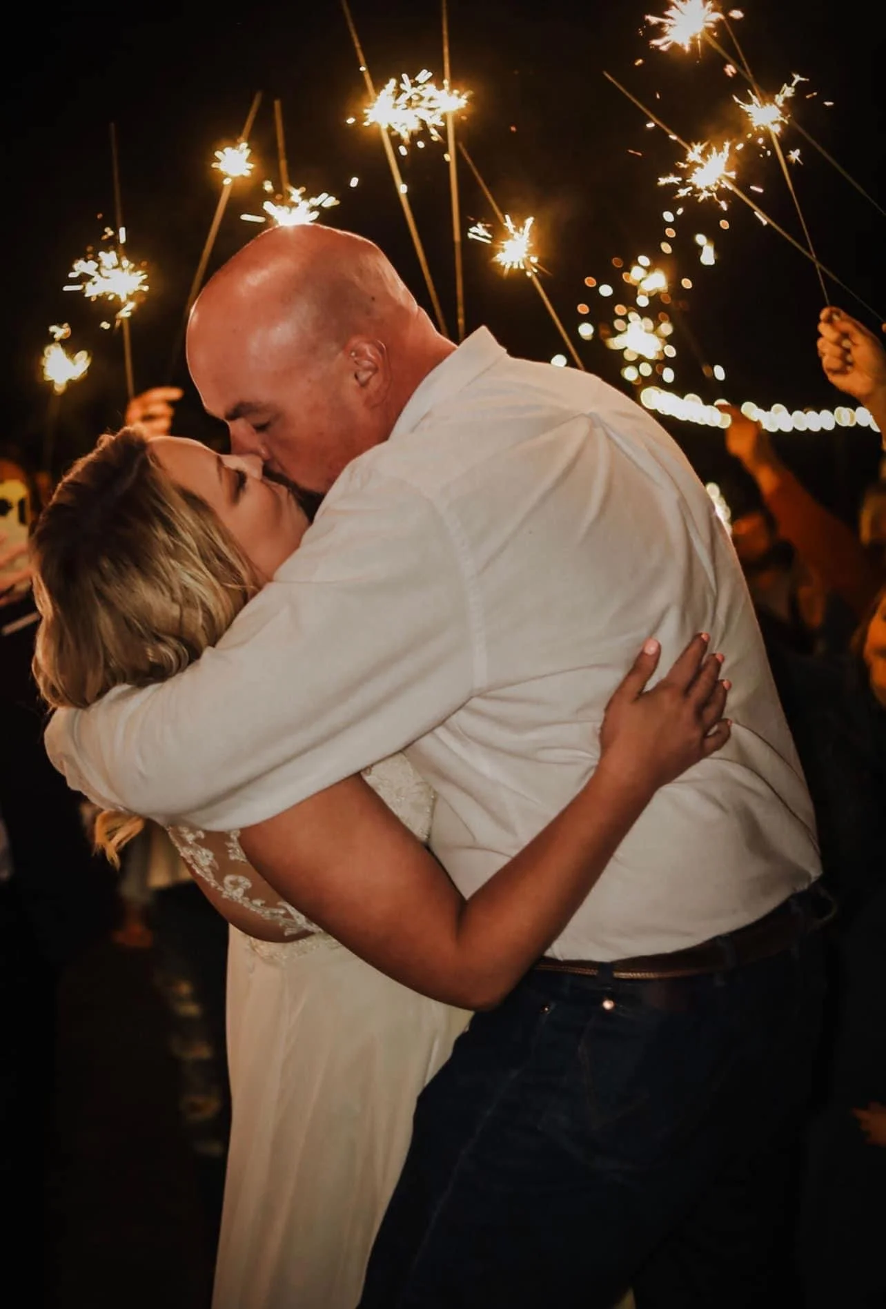 Laurie’s customers, Mariana and Carmen holding hands on a green lawn on their wedding day.