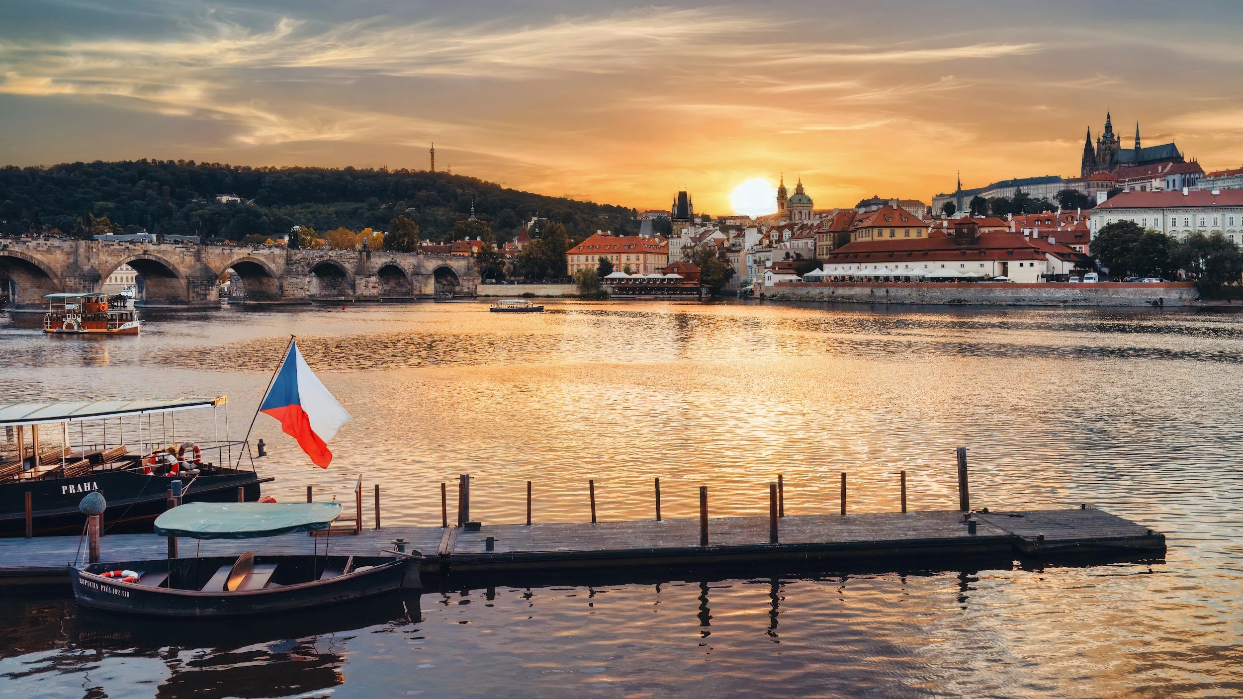 Sunset view of Prague Castle and Charles Bridge from the Vltava river