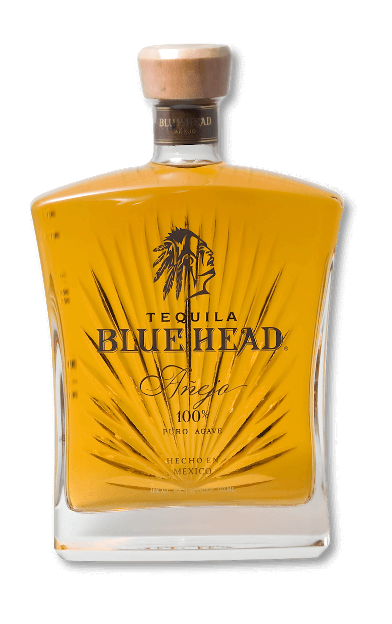 A bottle of Blue Head Anejo Tequila, featuring the logo on a clear glass bottle with intricate designs and a wooden cork.