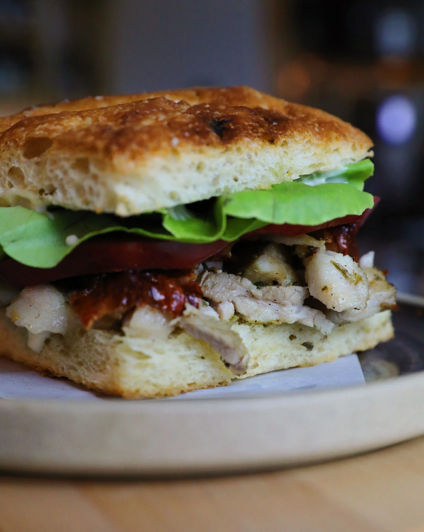 The PLT ✨ Juicy pork belly, lettuce, and tomato. Cured + crisped pork belly on fennel pollen focaccia with herb paste and Calabrian chili aioli. On the happy hour menu everyday.
