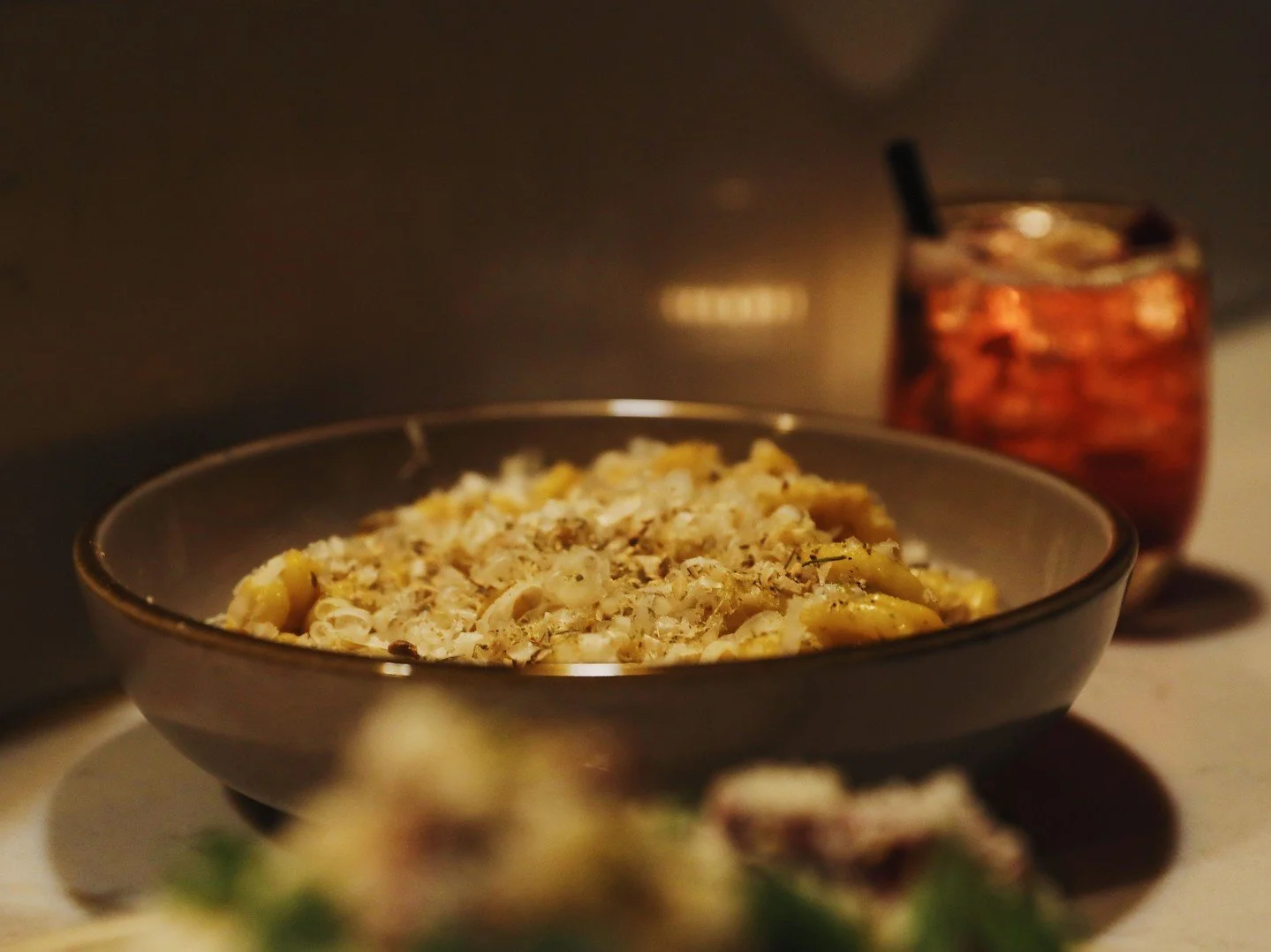 Gemelli at the bar, glowing under warm light. Easily the best seat in the house.