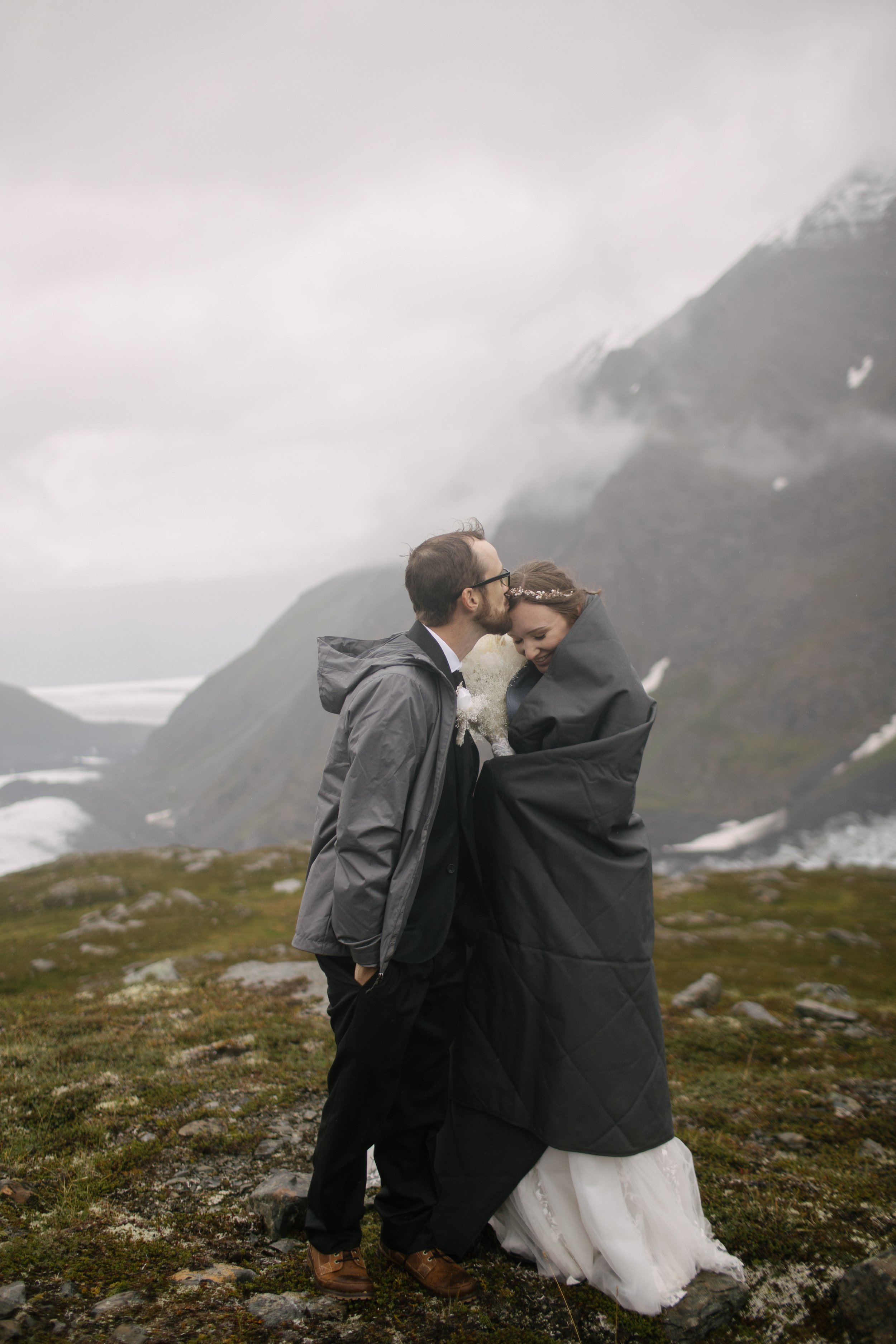 couple keeping cold after alaska elopement