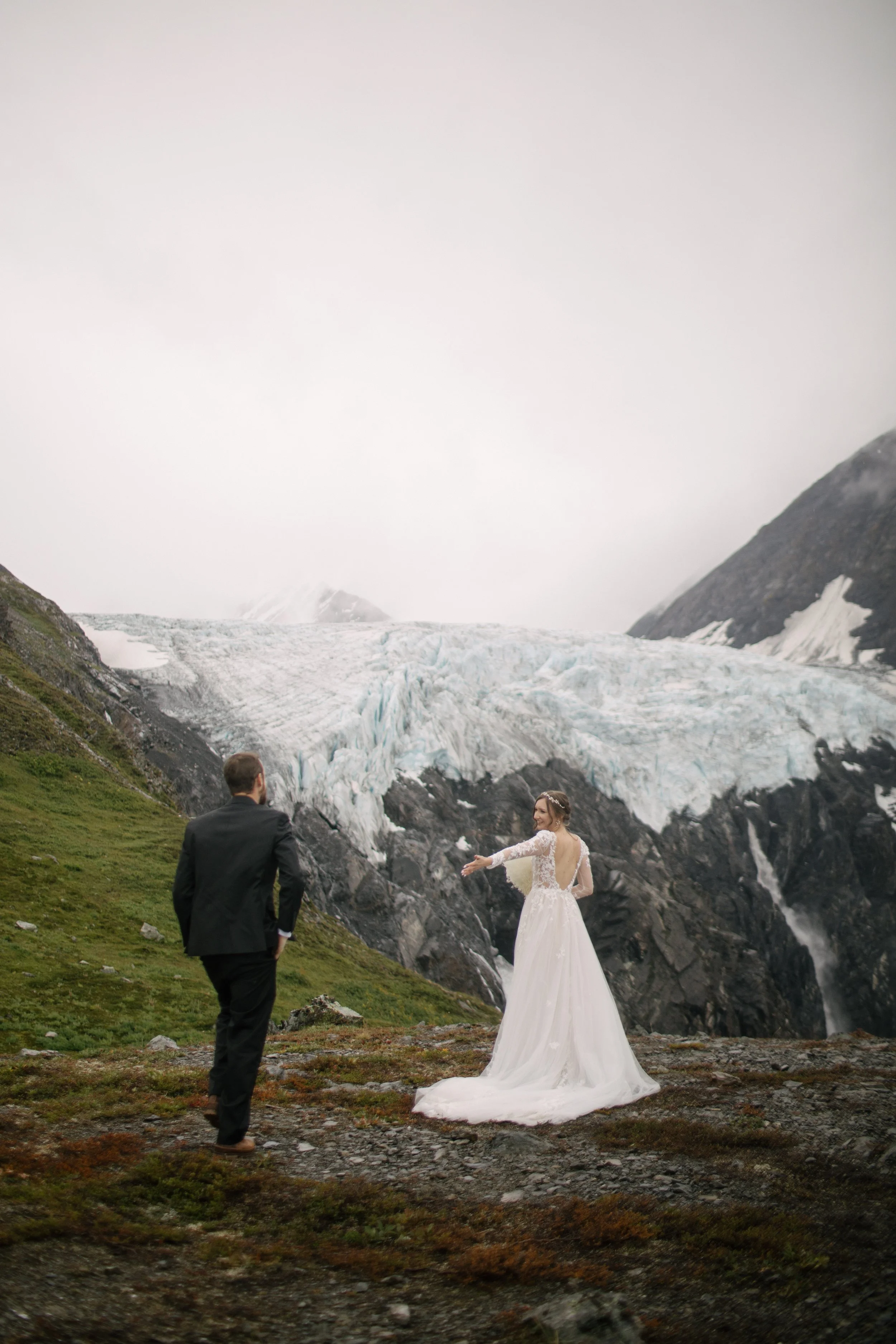 bride reaching hand to groom in alaska