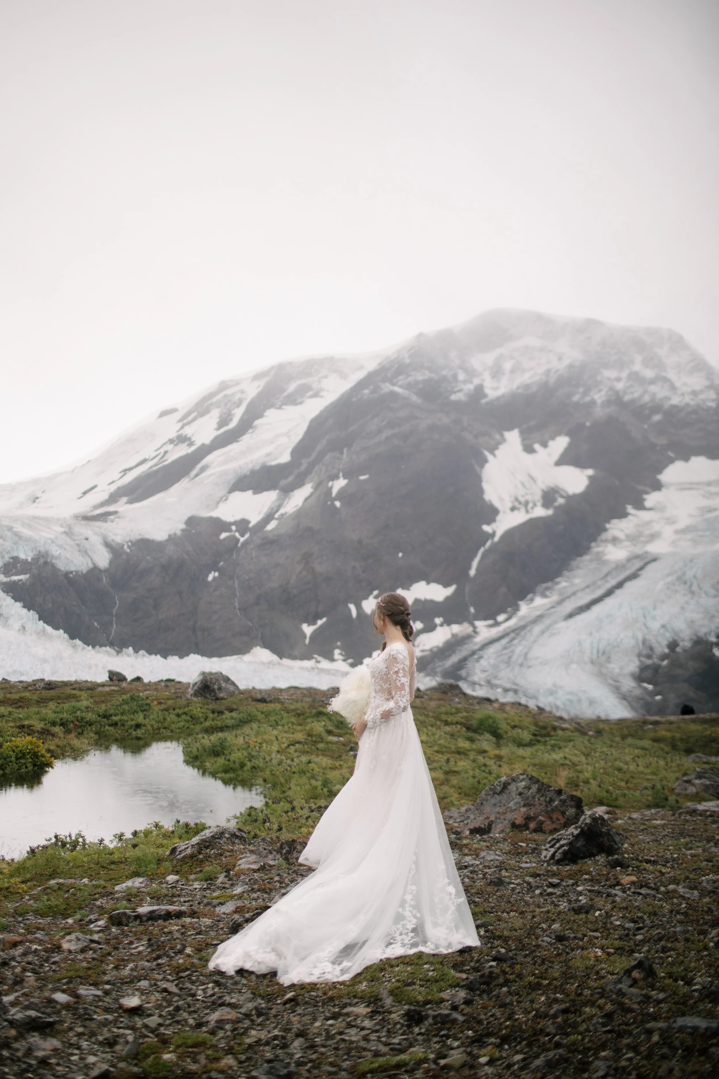 bride looks at glacier before elopement