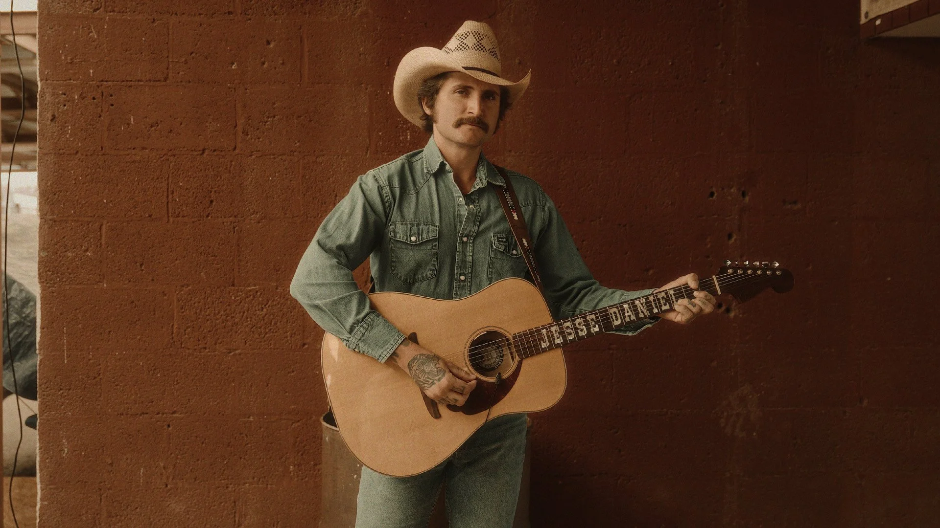 Jesse Daniel country musician holding guitar