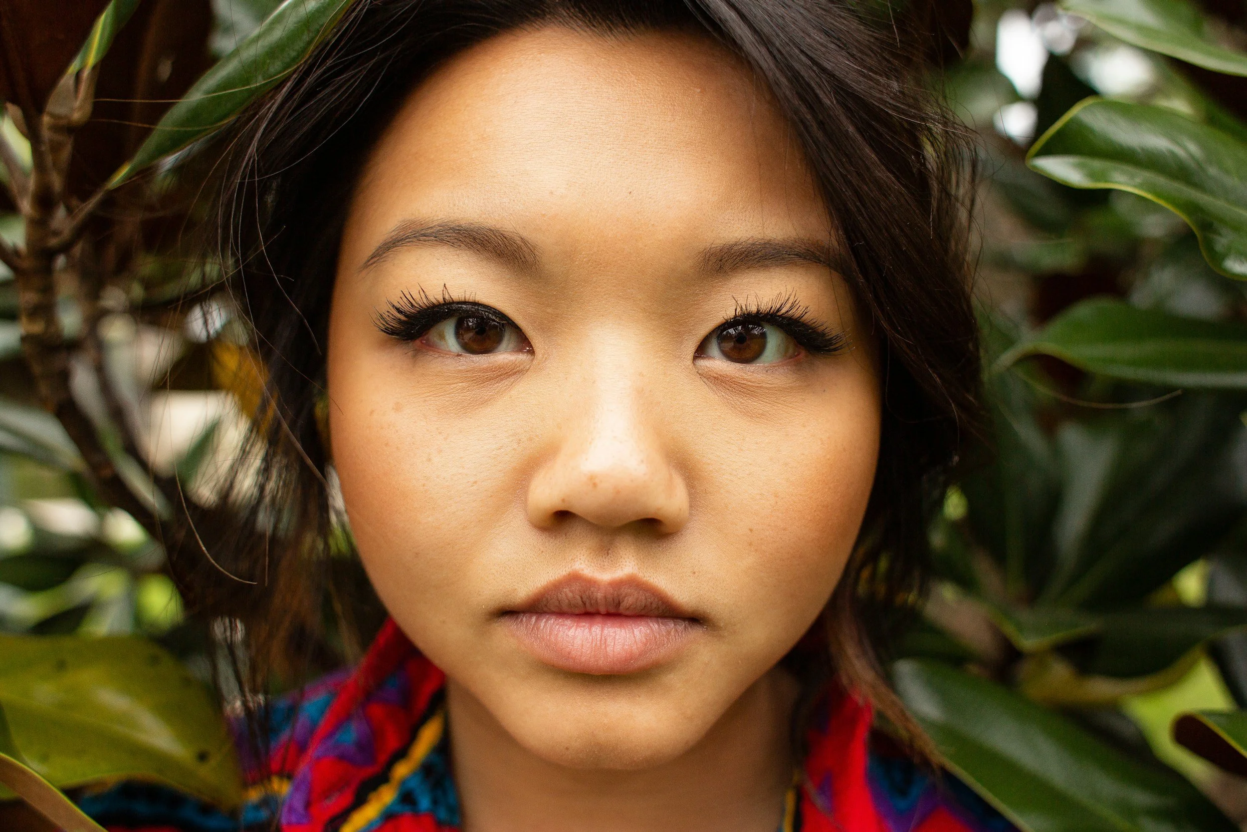 Asian woman with long eyelashes looking closely at screen