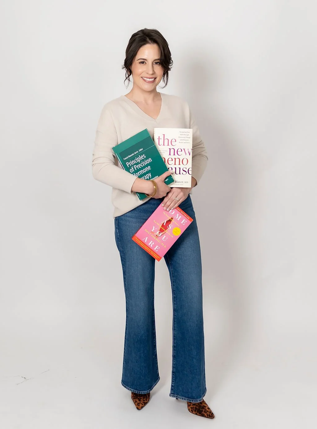 Andrea Martin holding a menopause and sexual health education books.