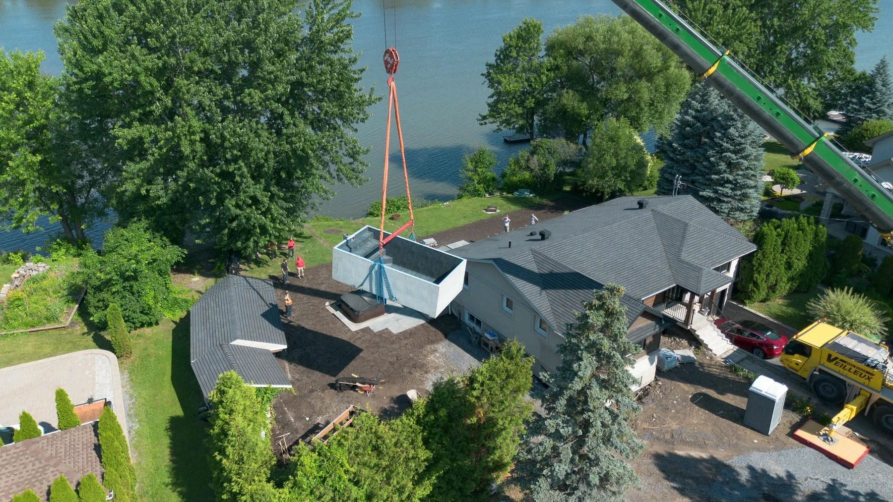 Aerial shot of a cement pool being transported by crane