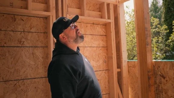 Worker looking at house being built