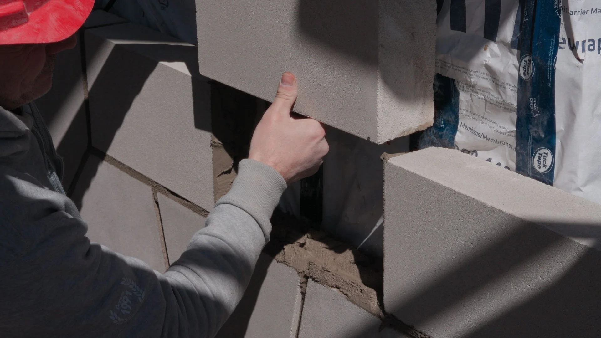 worker placing the last brick on a wall construction