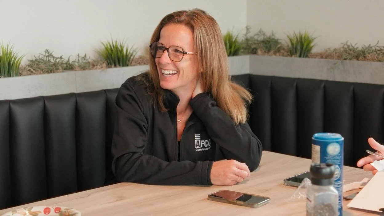 woman laughing and sitting at lunch table