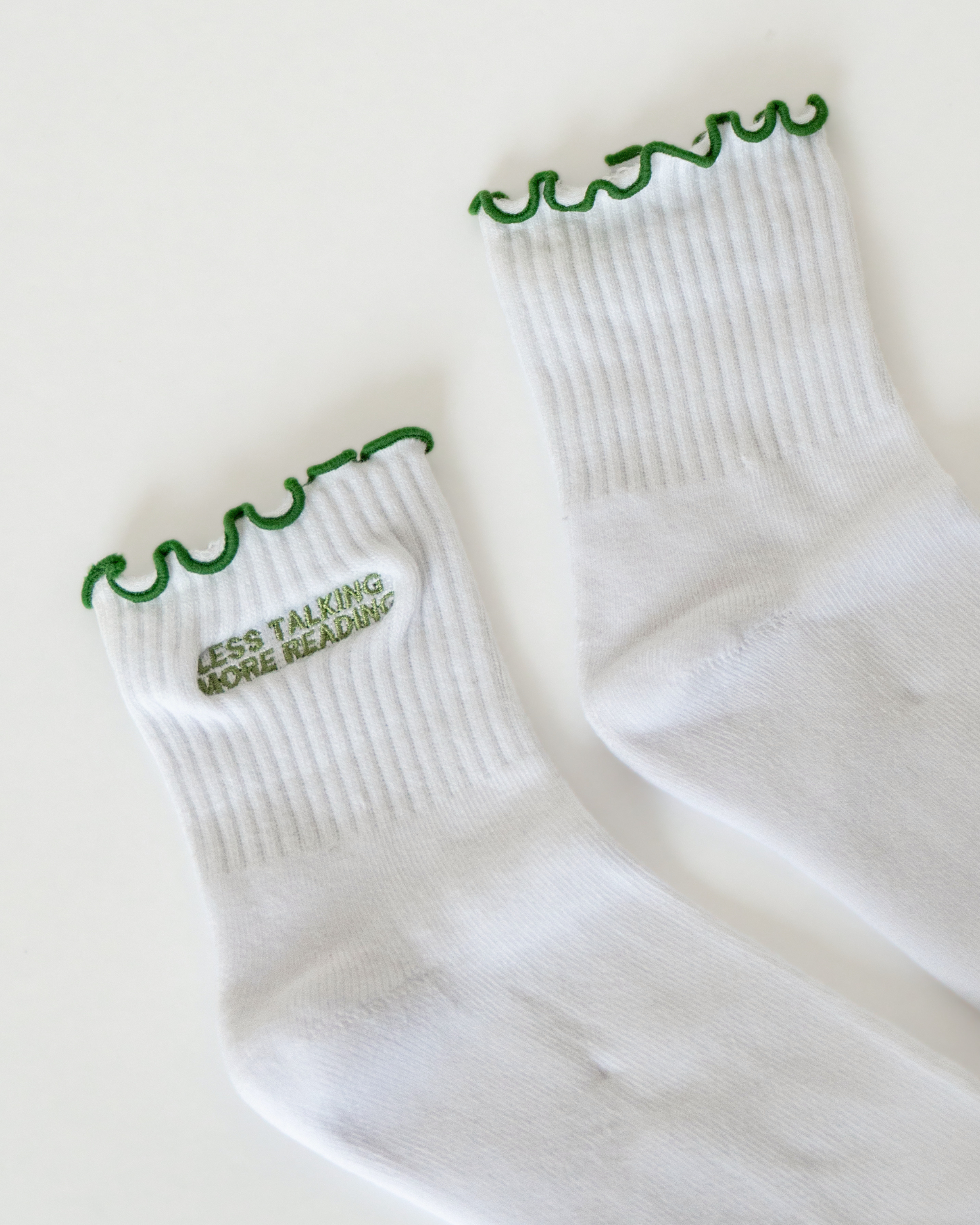 Bookish crew socks featuring embroidered reader-inspired sayings and designs, made for cozy reading days and gifting to book lovers.