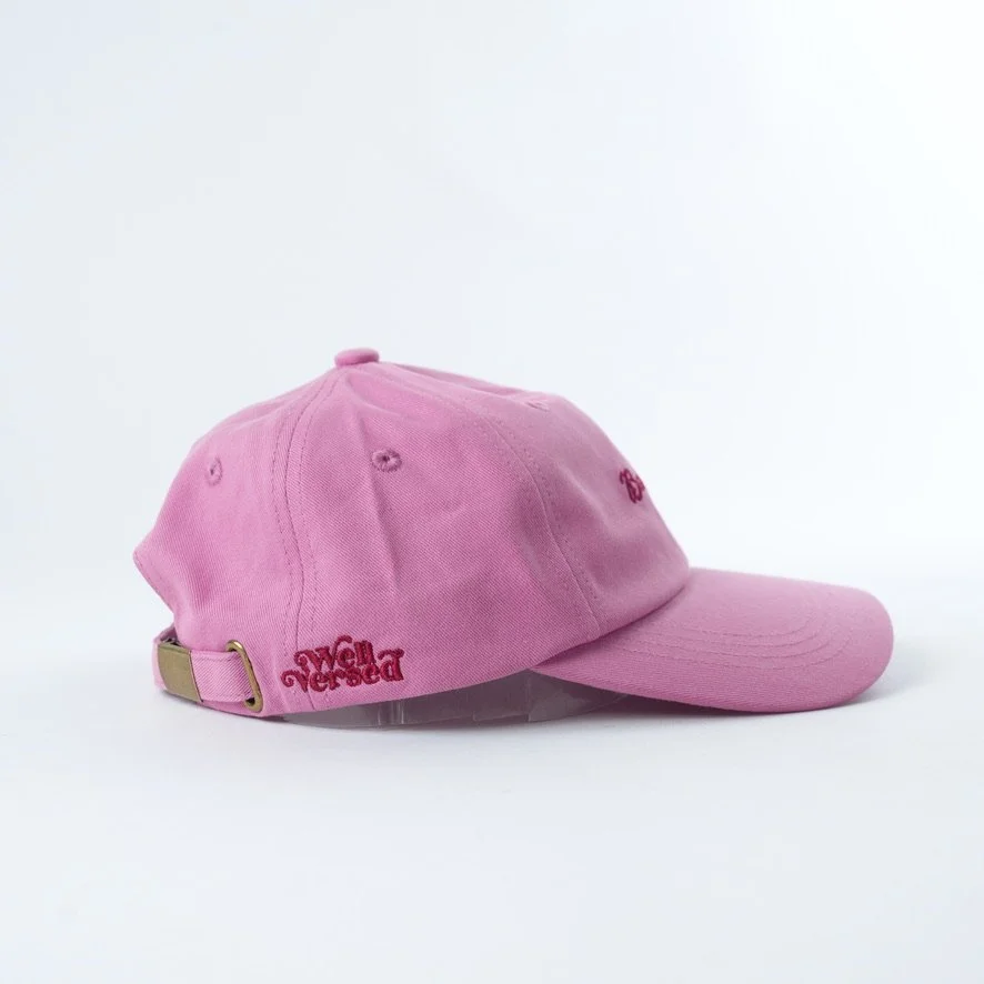 Pink embroidered hat that reads book lover in red cursive