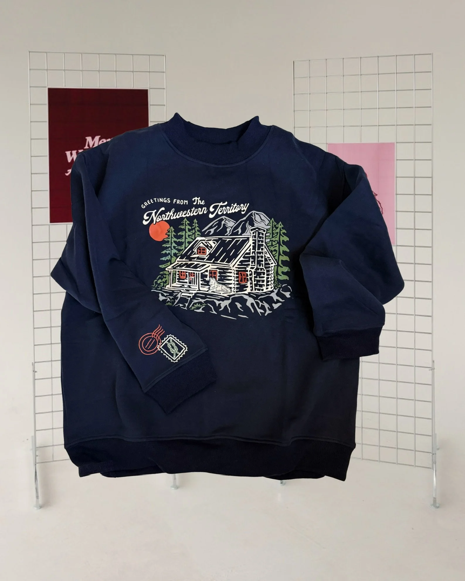 Navy mockneck sweatshirt featuring an illustration of Koen’s cabin inspired by Ali Hazelwood’s Mate, with a knot detail printed on the sleeve.