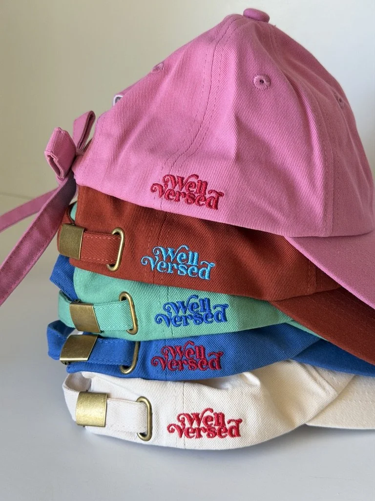 Mint green baseball cap embroidered with the phrase “SORRY I'M LATE I WAS READING” in bright blue lettering.