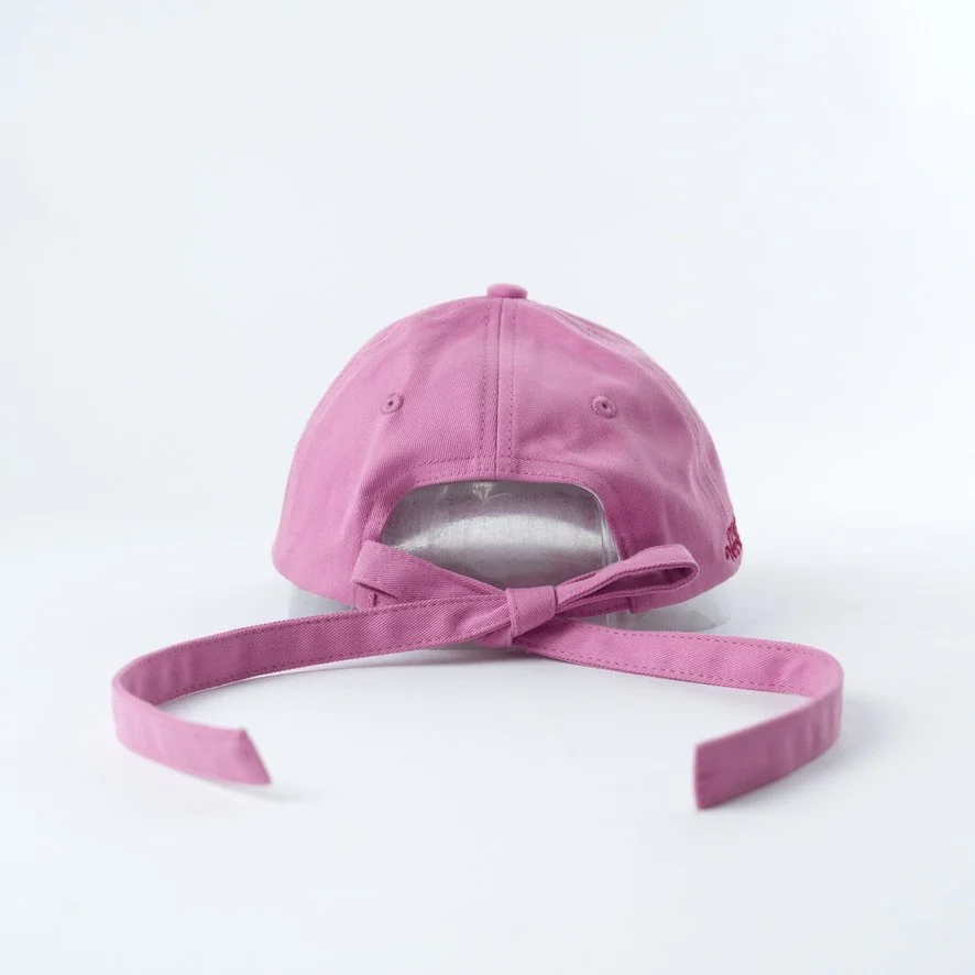Pink embroidered hat that reads book lover in red cursive with a bow back instead of a metal clasp