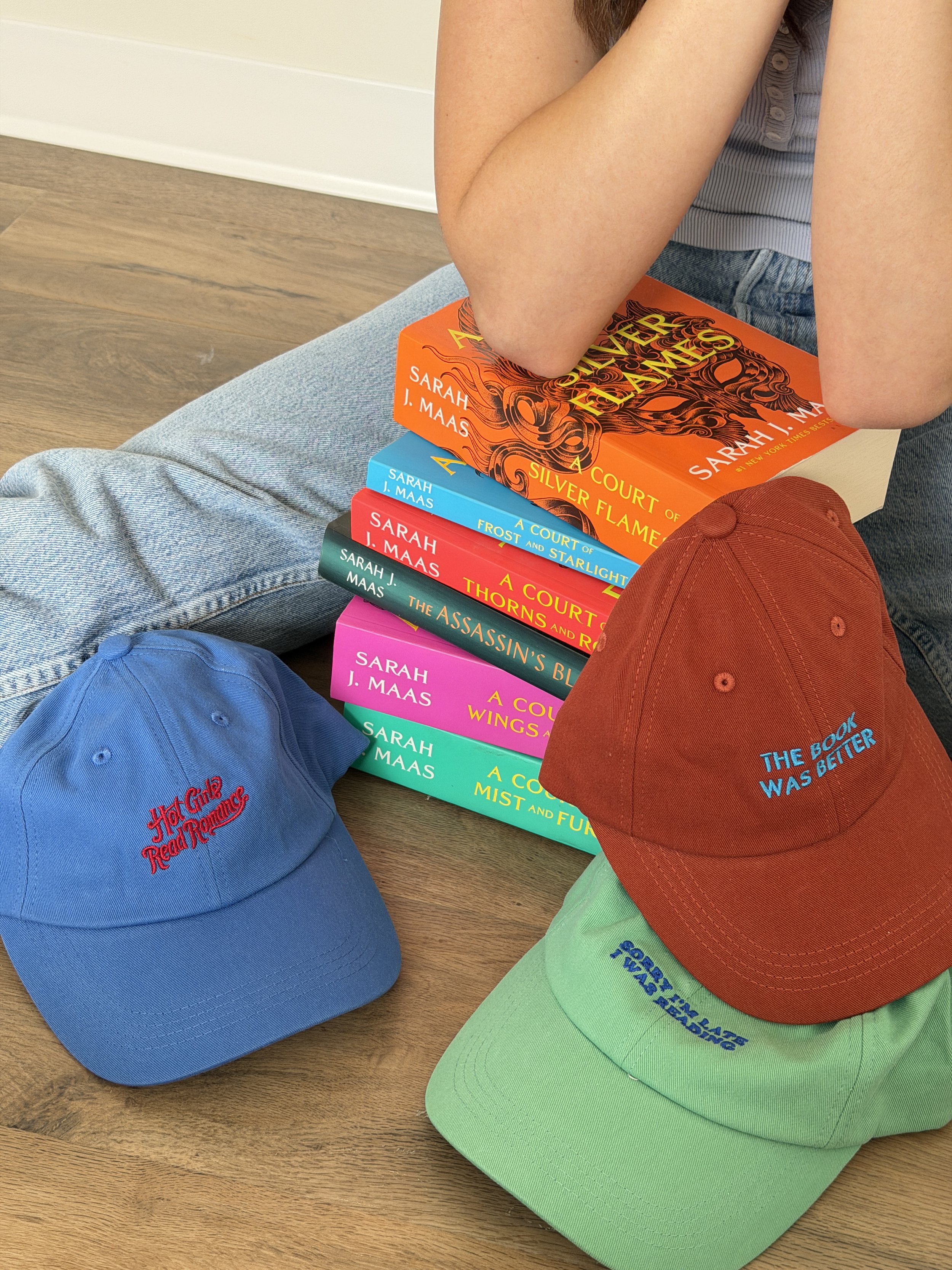 Light blue baseball cap embroidered with the phrase “Hot Girls Read Romance” in red script lettering.