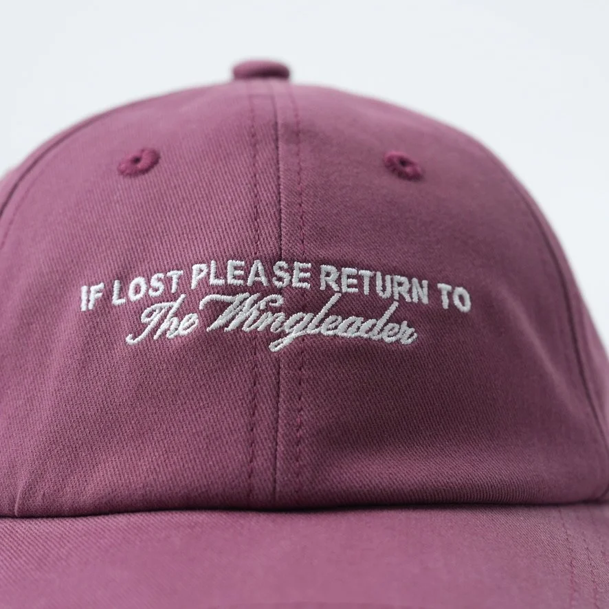 Purple baseball hat that reads If lost please return to the wingleader