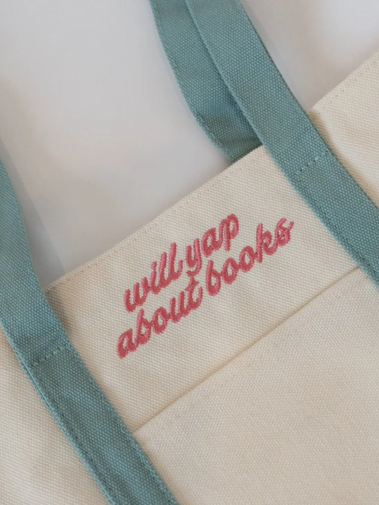 Will Yap About Books embroidered canvas tote bag with blue straps and pink lettering, a cute bookish tote for readers, book lovers, bookstore trips, and book club gifts.