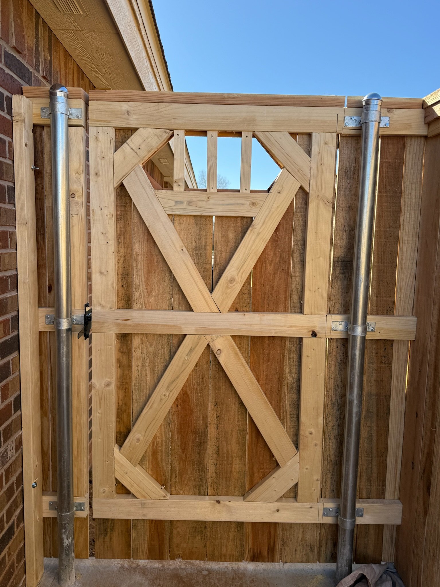 Wooden fence gate with metal poles