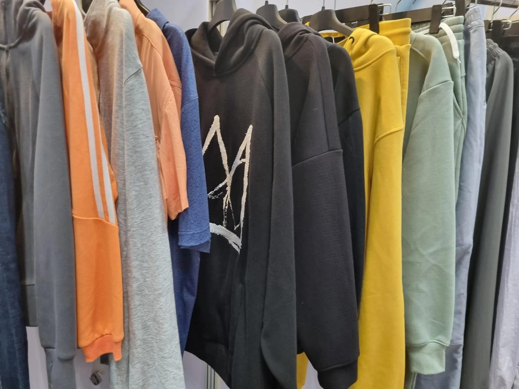Custom apparel manufacturer booth at a textile trade show highlighting OEM and ODM clothing production services.