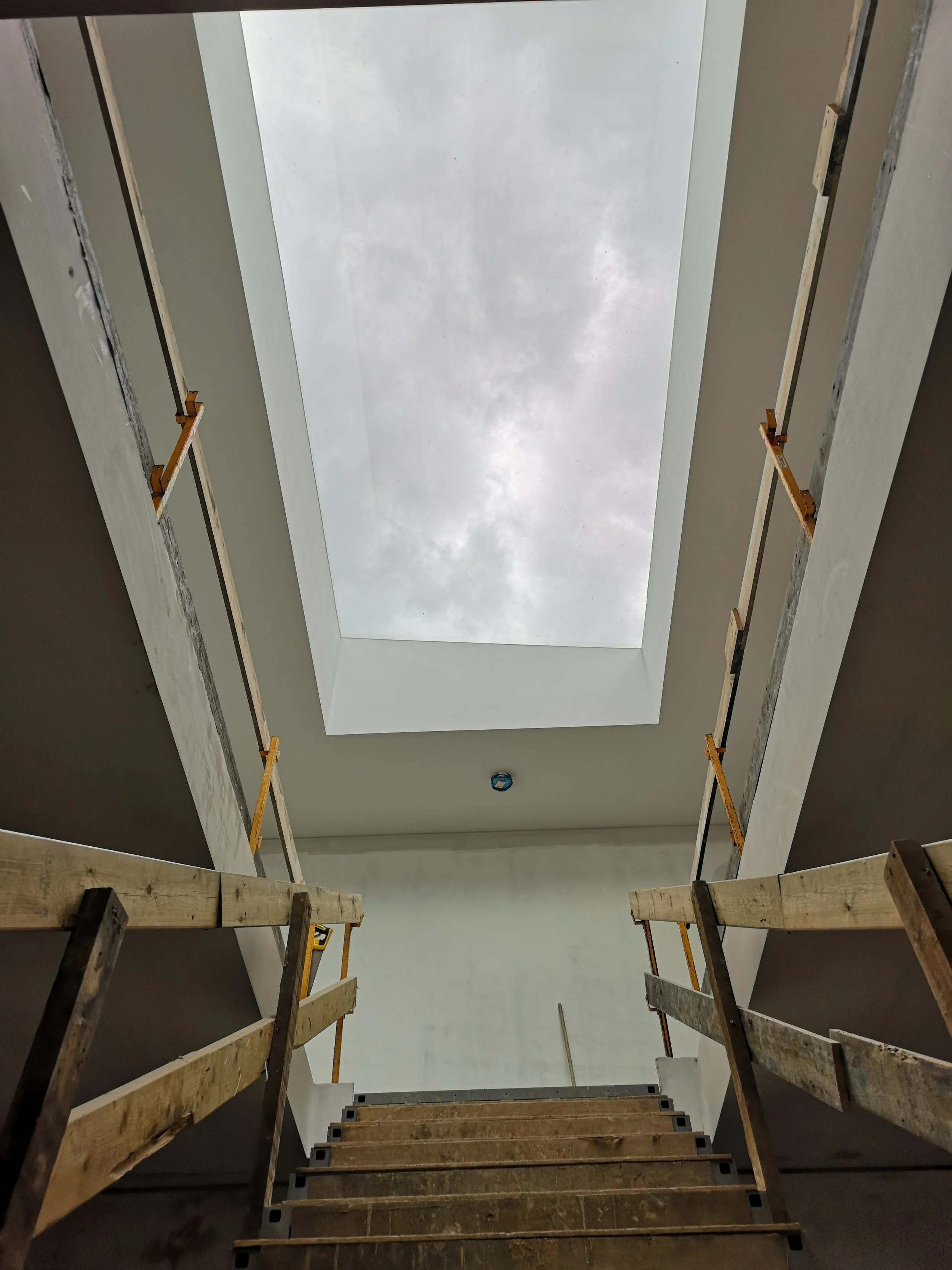 Pell Stevens Architects West Sussex countryside home. Internal entrance hallway and staircase with large roof light. Spacious and light hallway.