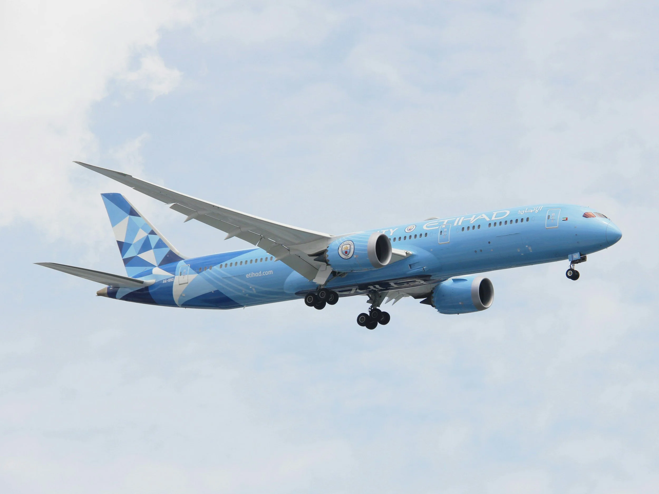 Light blue Etihad 787 with flaps down approaching to land