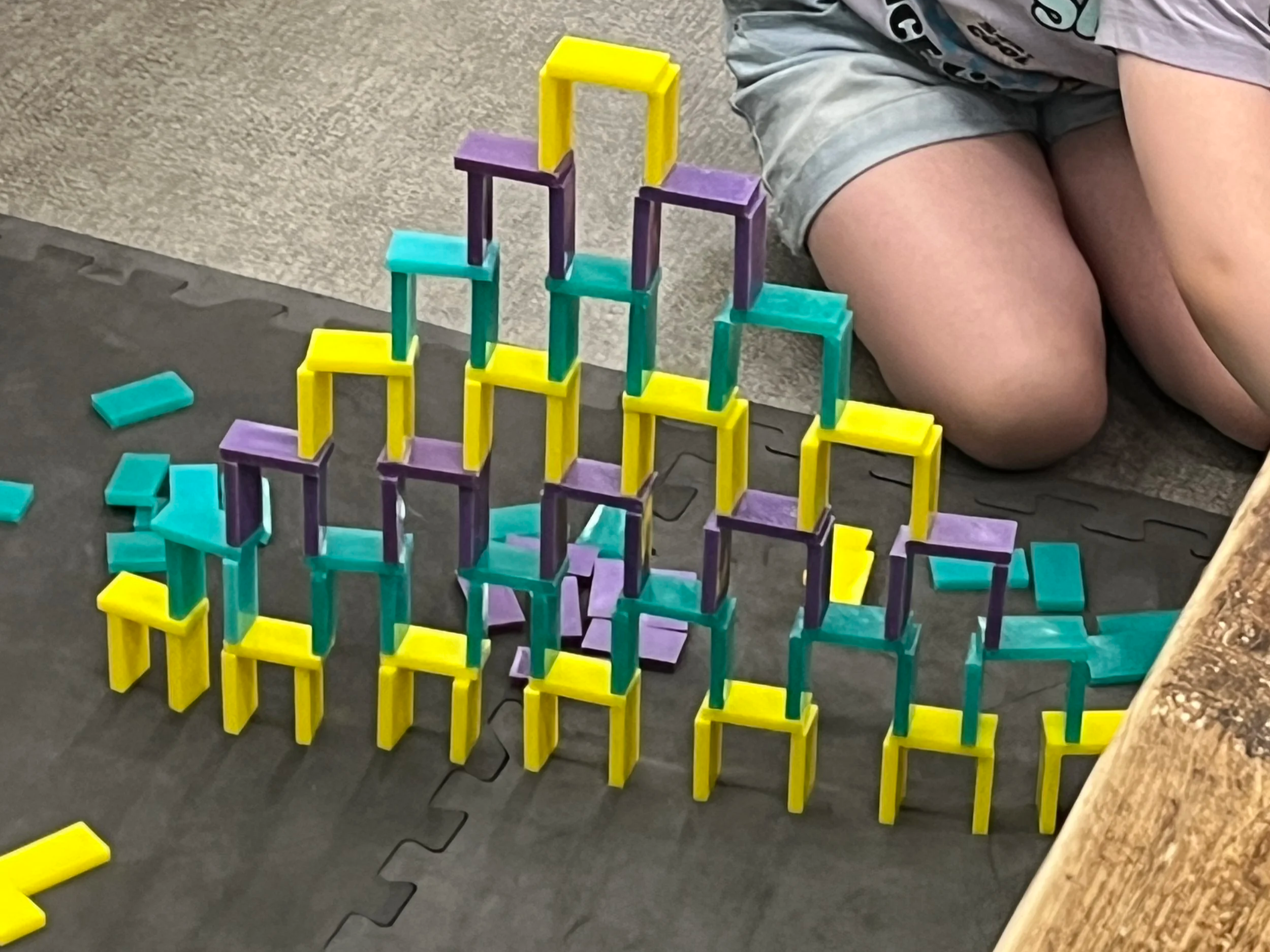 Domino 'speedwall' pyramid in yellow, teal and purple.