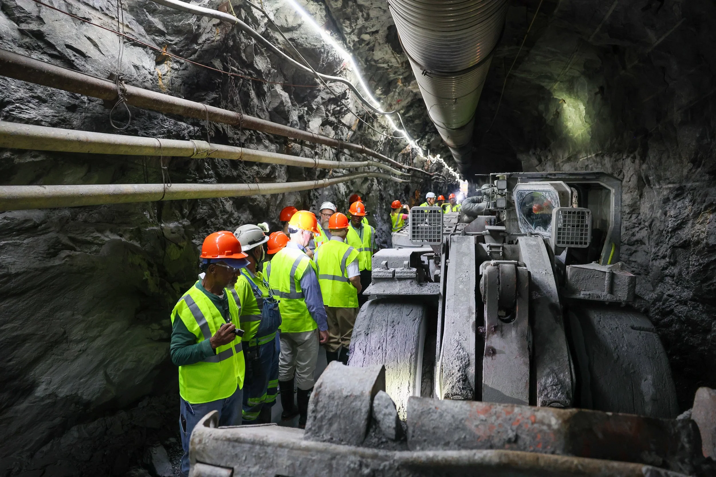 Guests of the Tunnel Tours walk past equipment in the excavated tunnel path.