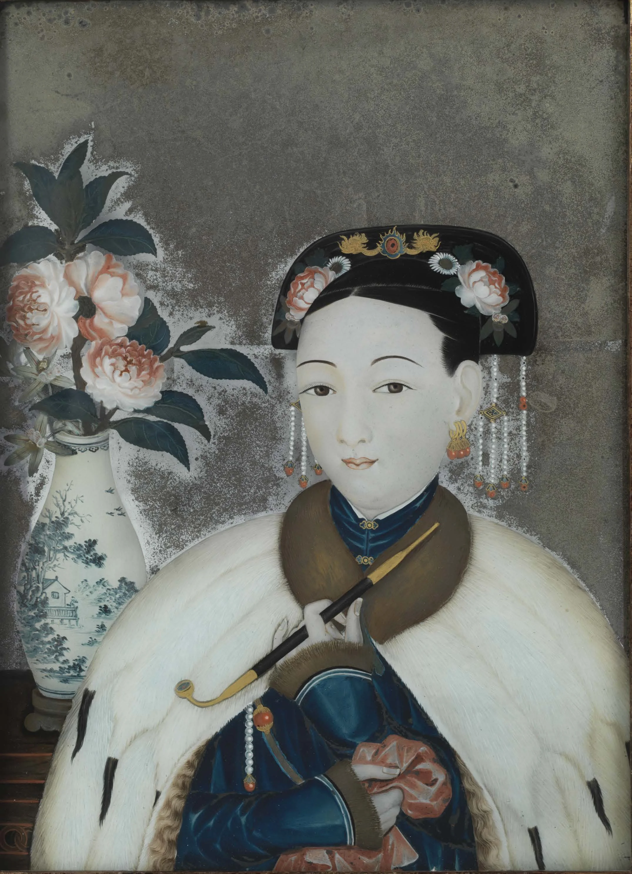 A traditional Asian portrait of a woman wearing elaborate jewelry and clothing, with a large hat decorated with flowers, and holding a pipe. A vase with flowers is visible in the background.