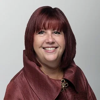 Smiling Caucasian woman with short red hair on a grey backdrop