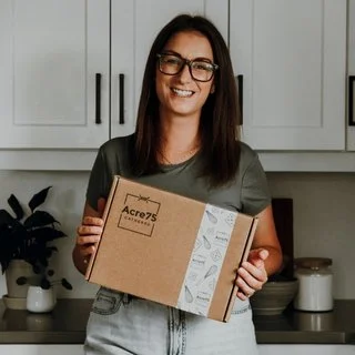 Person holding "Acre75 Gathered" box in kitchen