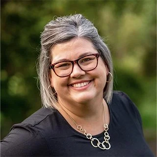Smiling aucasian woman with short greying hair and glasses