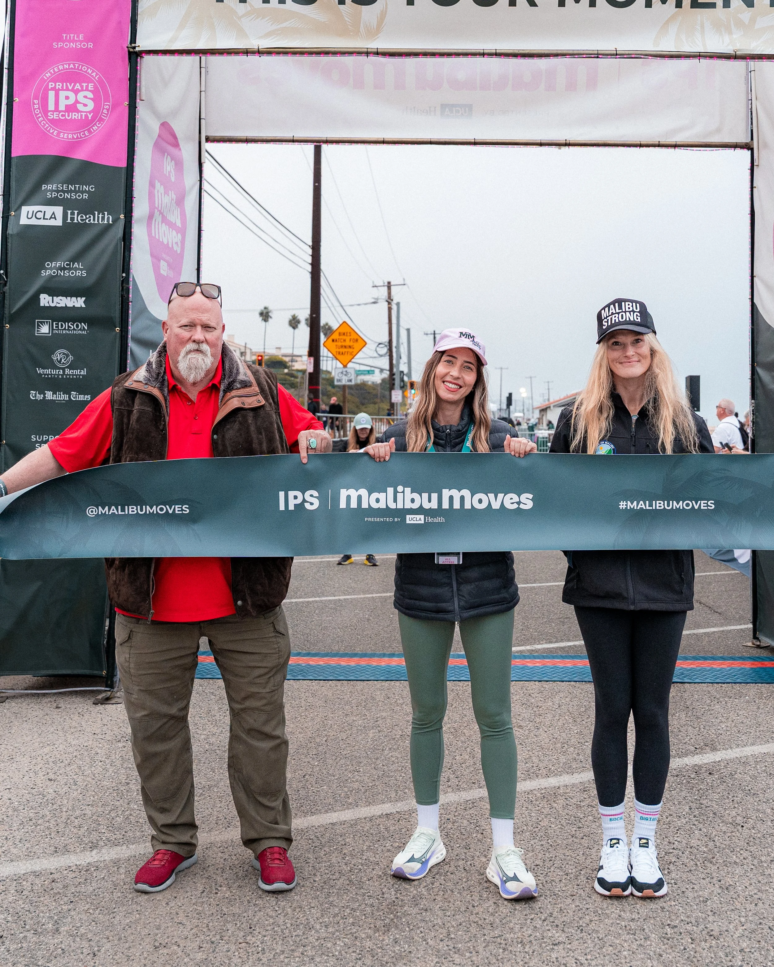 IPS Founder Aaron T. Jones, Malibu Moves Founder Segel, and Malibu Councilmember Conrad holding the finish line tape