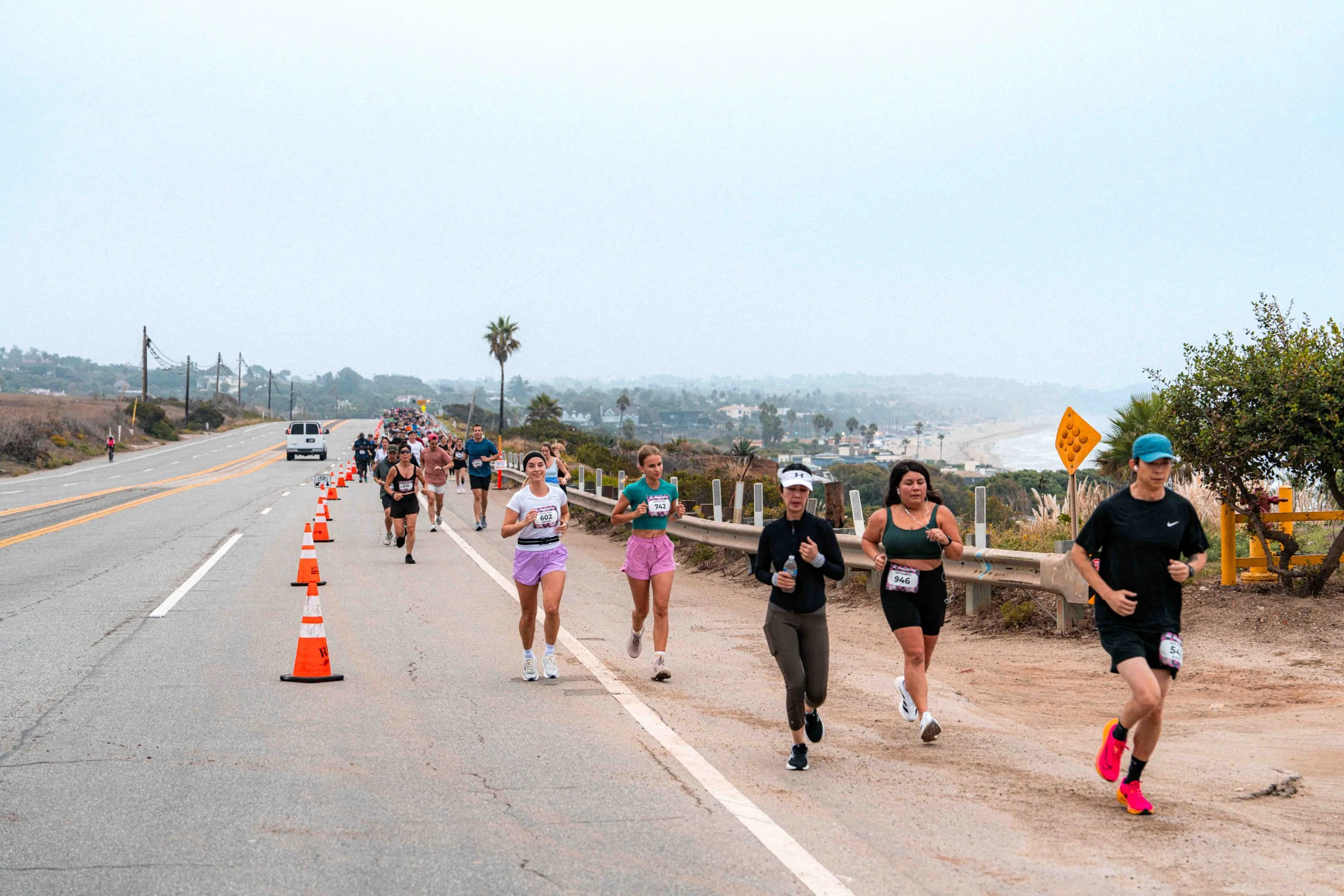 Runners on Pacific Coast Highway during the Malibu Moves Half Marathon with ocean and mountain views