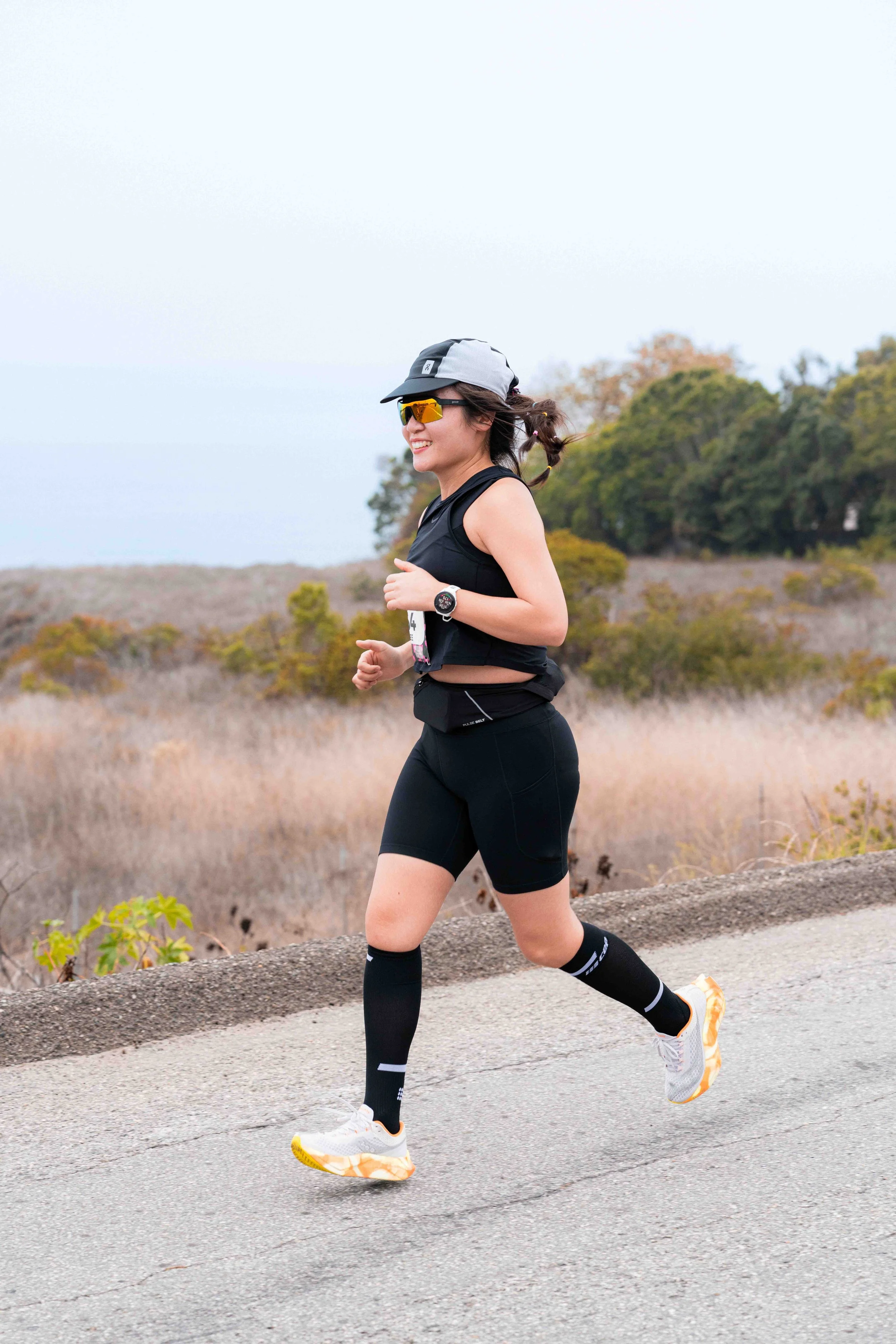 Runner training along Pacific Coast Highway in Malibu with the Pacific Ocean and Santa Monica Mountains in the backgroun.