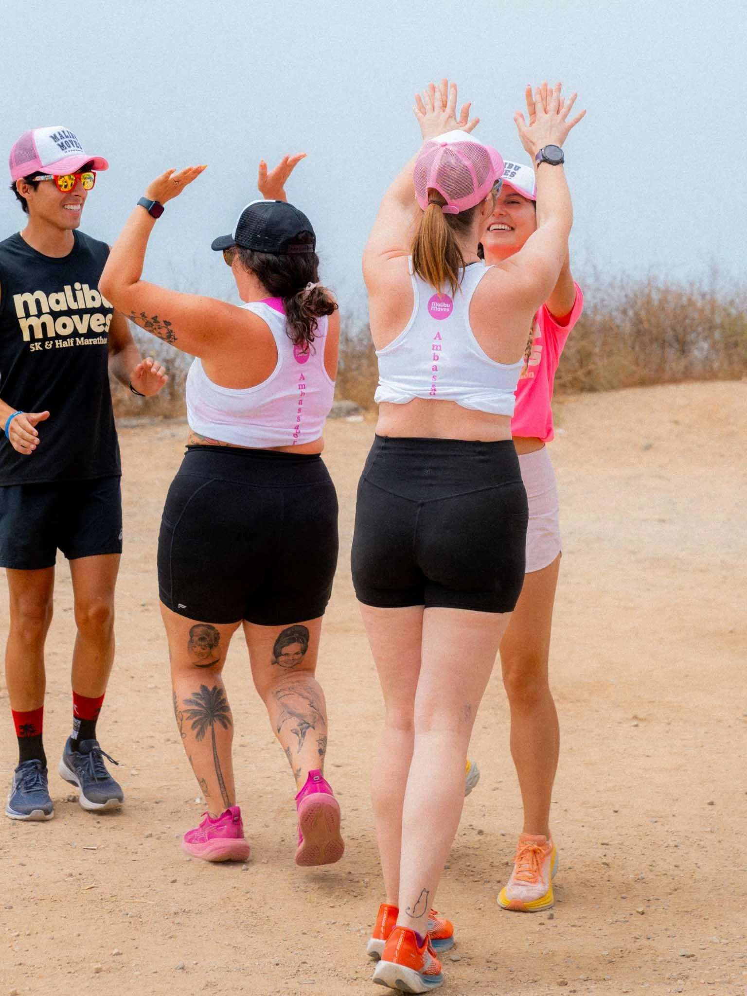 Malibu Moves Ambassadors high-fiving each other after a fun run at Zuma Beach
