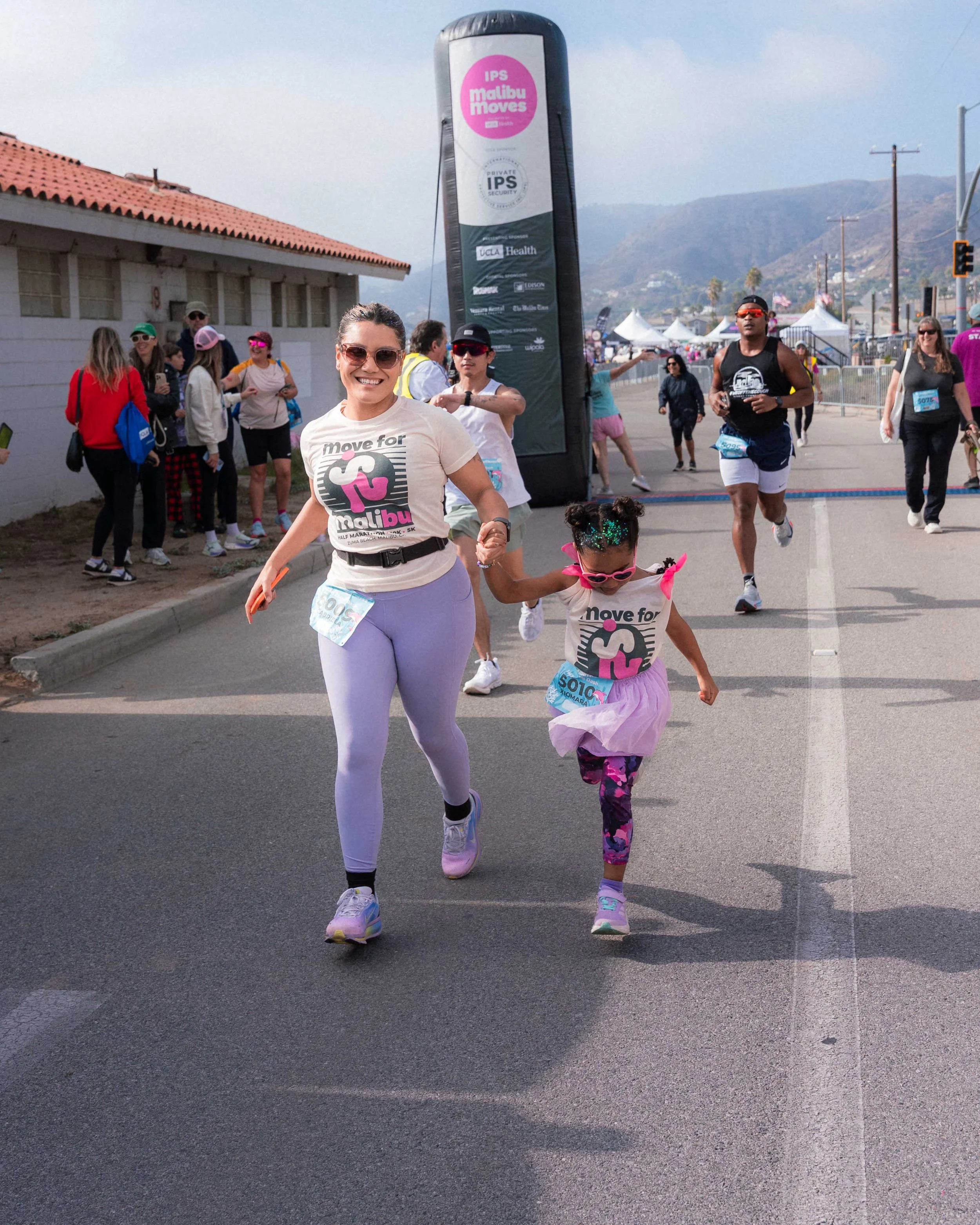 Families and participants of different ages taking part in the Malibu Moves 1-Mile Zuma Dash at Zuma Beach in Malibu, California.