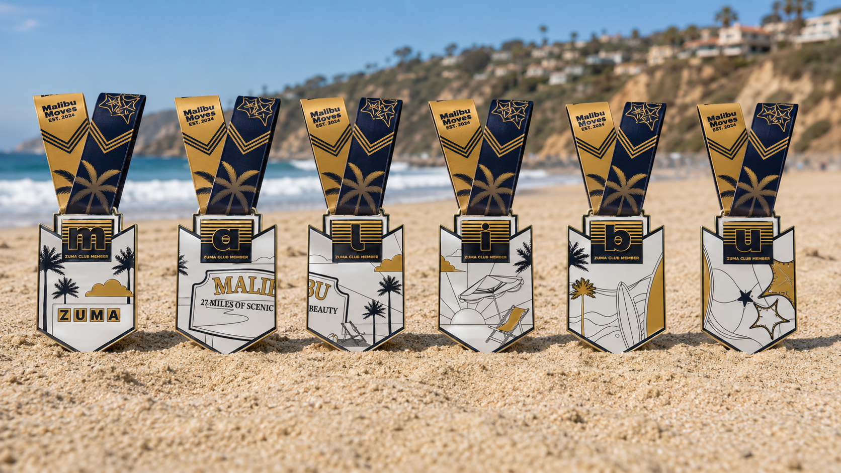 Six connected medals spelling MALIBU, the Zuma Club collection, at Zuma Beach.
