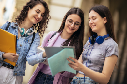 Three teenagers looking at a document.