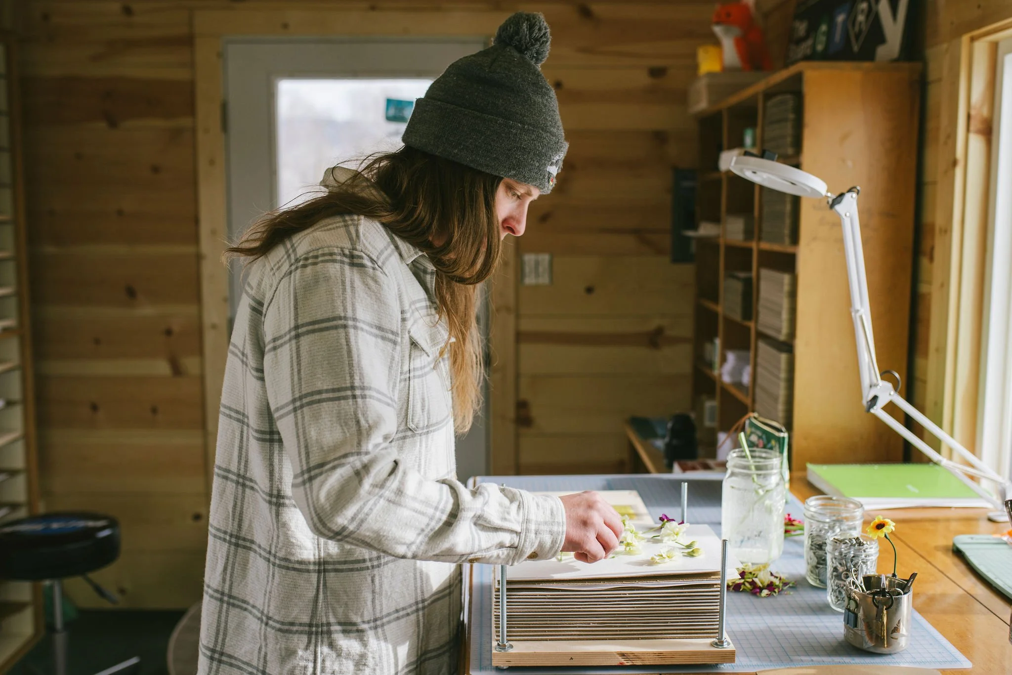 An image of the artist in her studio pressing stock flowers.