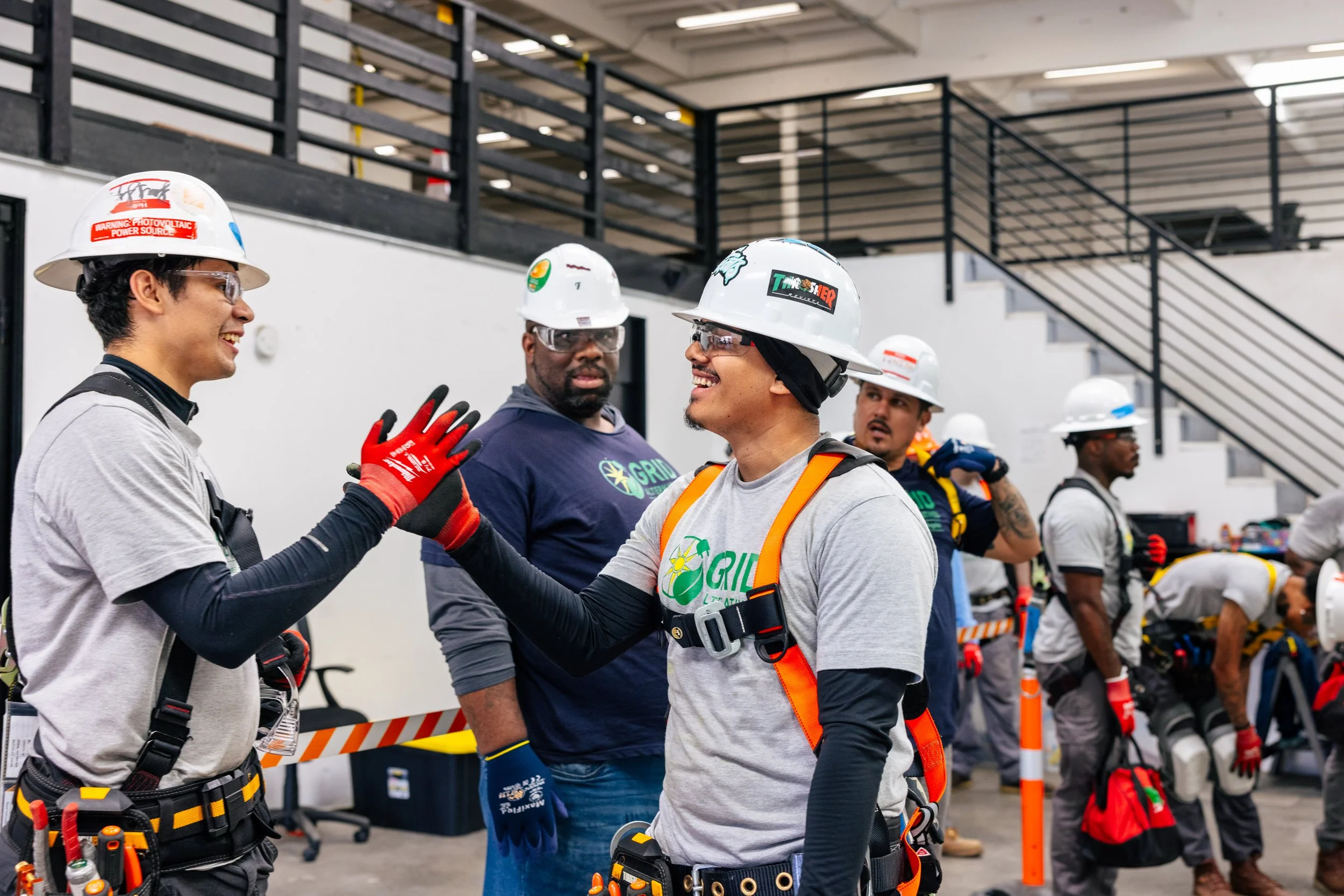 GRID Alternatives IBT 200 solar installation trainees share a candid moment at the training facility in Los Angeles, California.