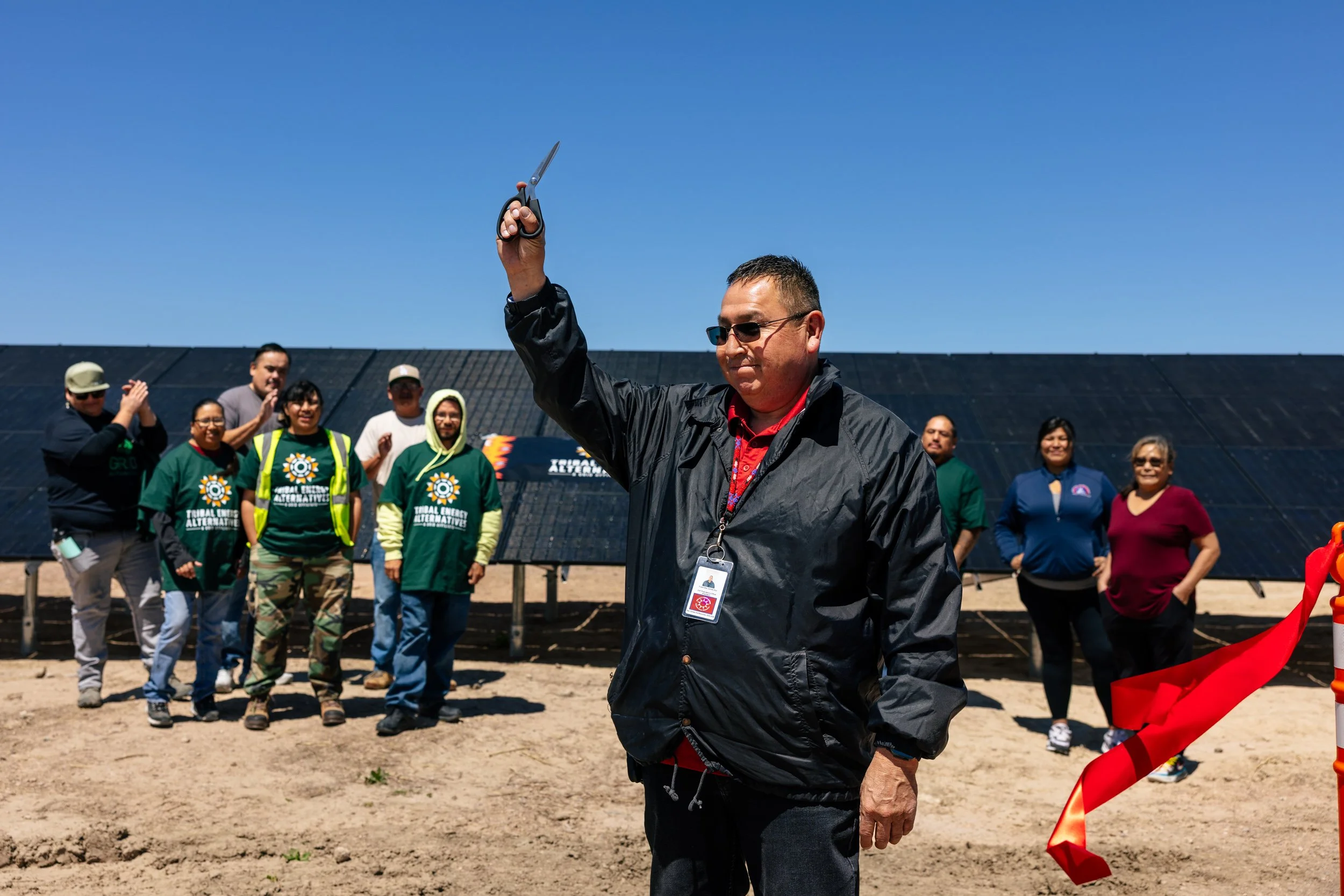 A community leader celebrates alongside GRID Alternatives installers and community members at the completion of a solar installation at the Pine Ridge Indian Reservation, South Dakota.