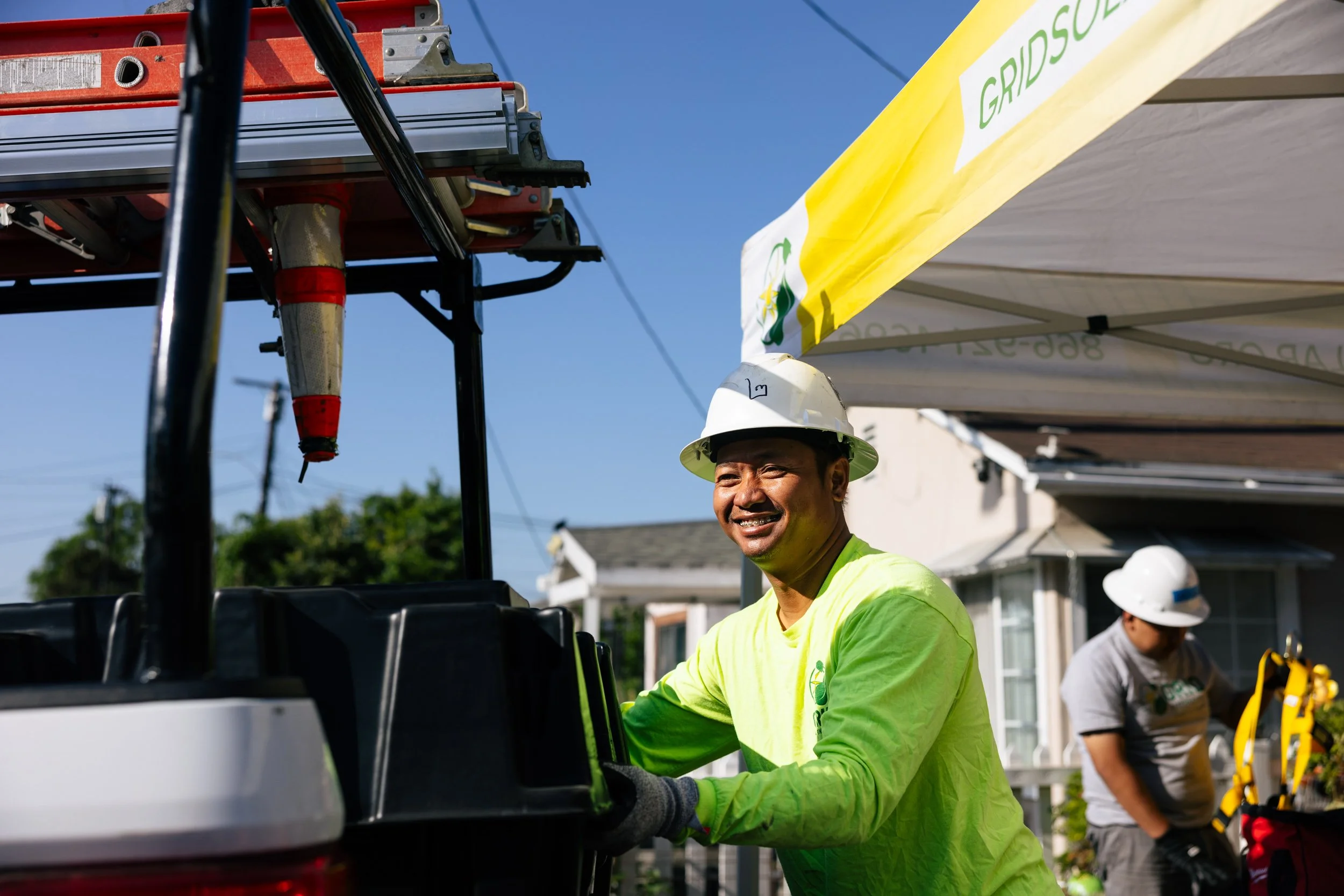 A GRID Alternatives installer unloads solar equipment from a truck at a residential installation site in Los Angeles, California.