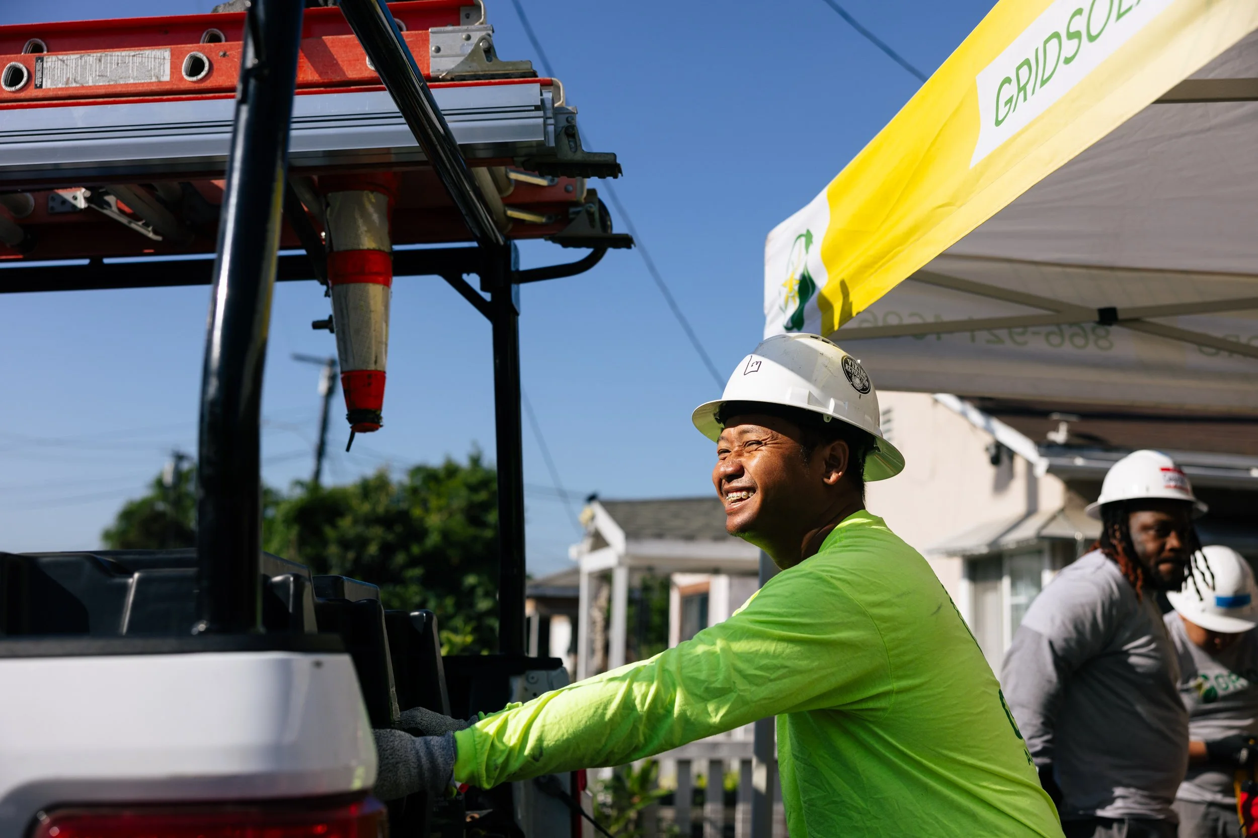 GRID Alternatives installer unloads solar equipment from a truck at a residential installation site in Los Angeles, California.